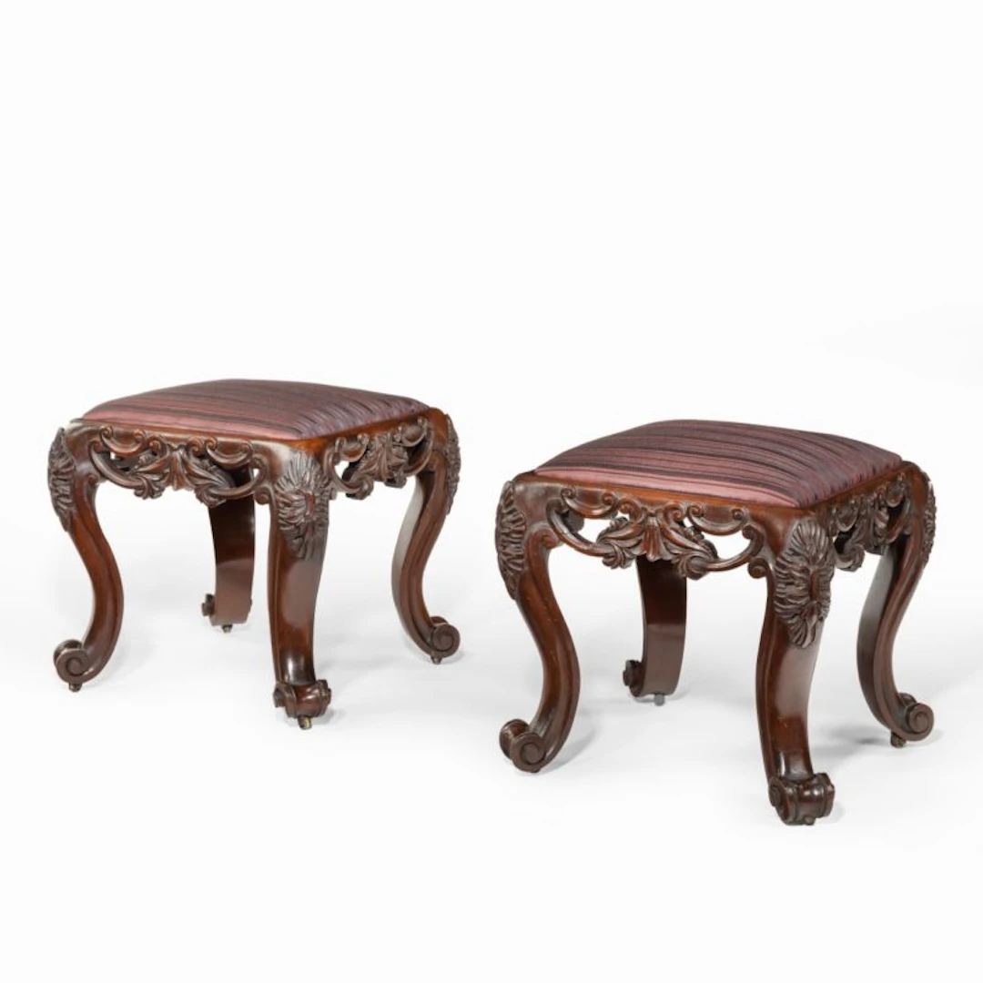 A pair of Victorian carved mahogany stools