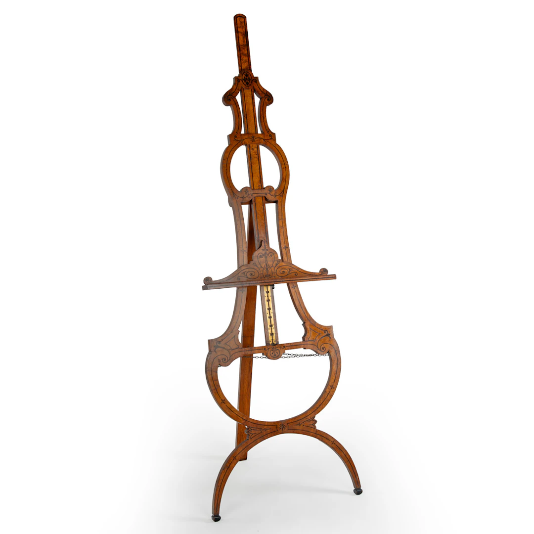 A fine Victorian brown oak and marquetry easel of elegant scrolled form