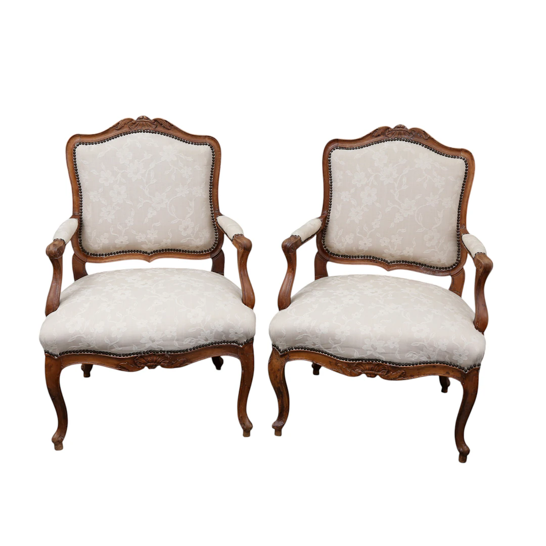 Pair of Louis XV “à la reine” French armchairs in carved walnut, 18th century.