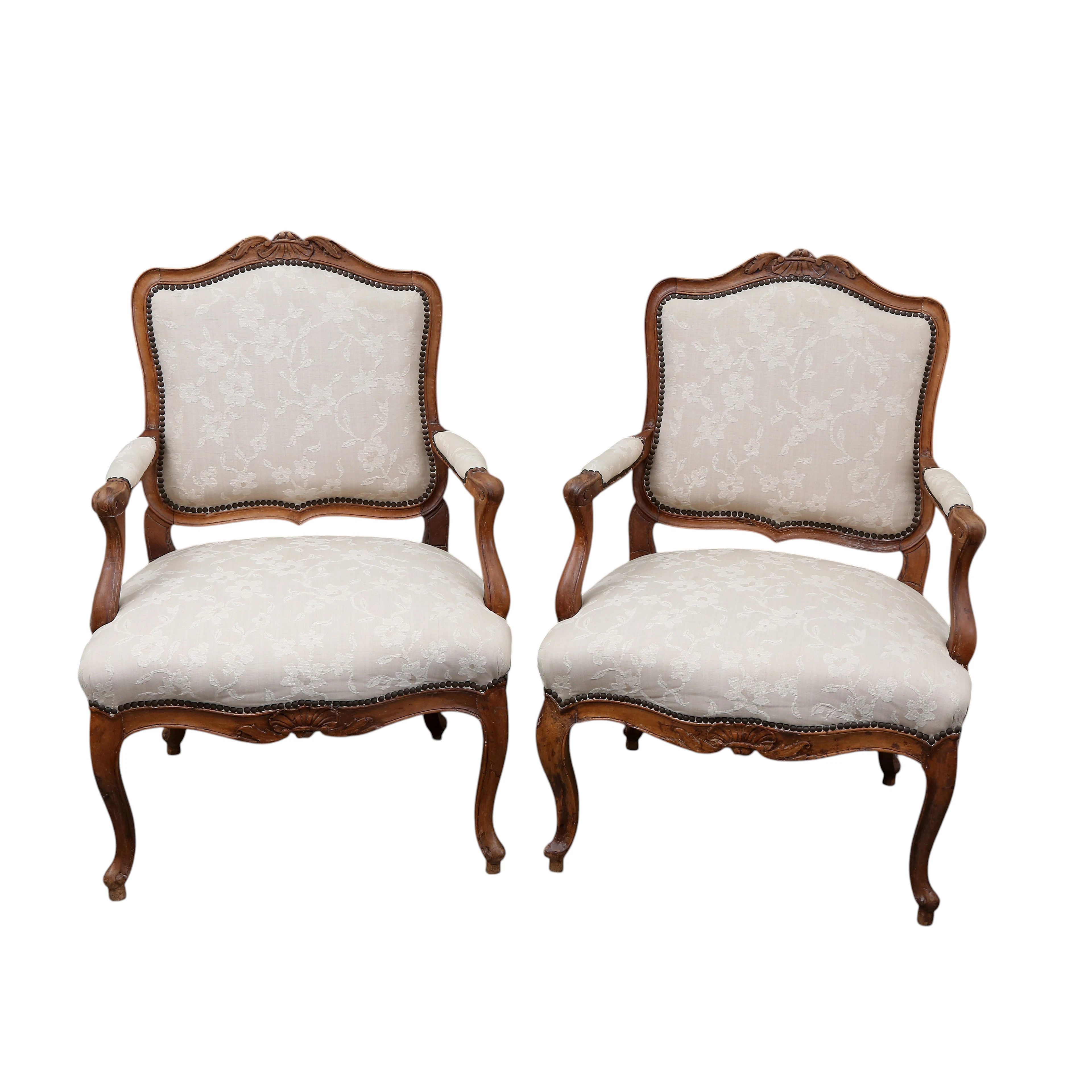 Pair of Louis XV “à la reine” French armchairs in carved walnut, 18th century.