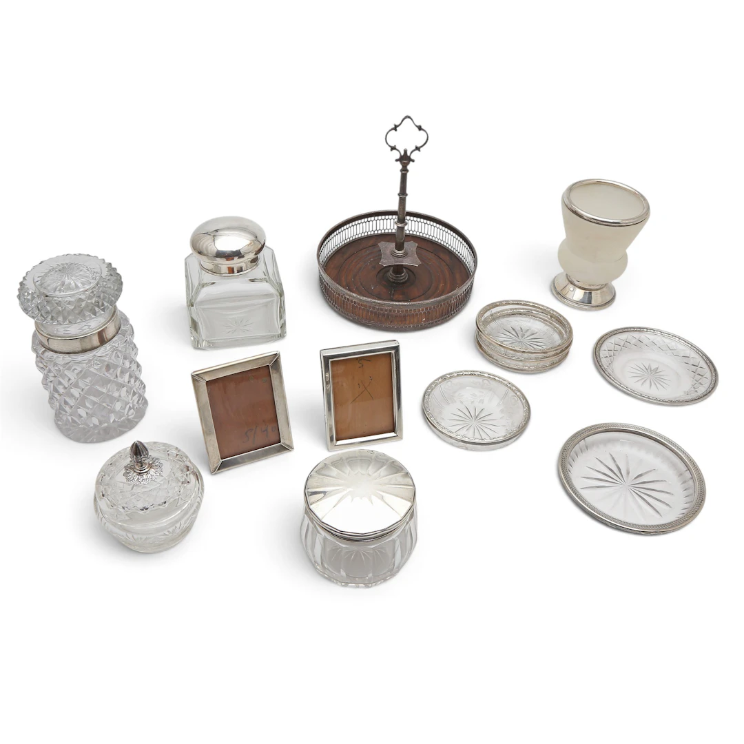 Various serving objects and small frames in silver, glass, alabaster and wood.