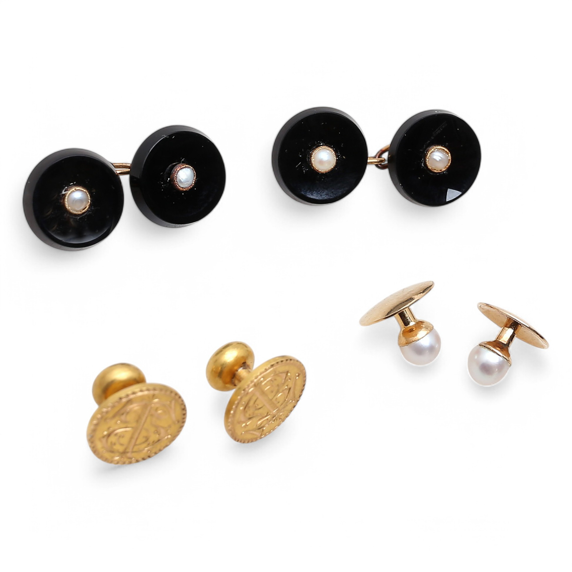 Two pairs of gold buttons and metal cufflinks.