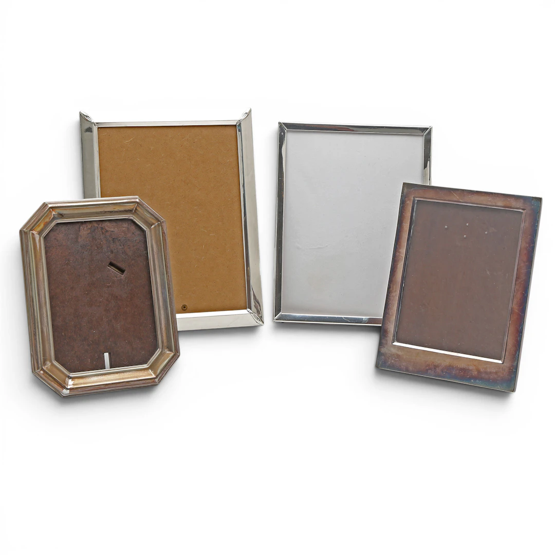 Two picture frames in silver and two in silvery metal.