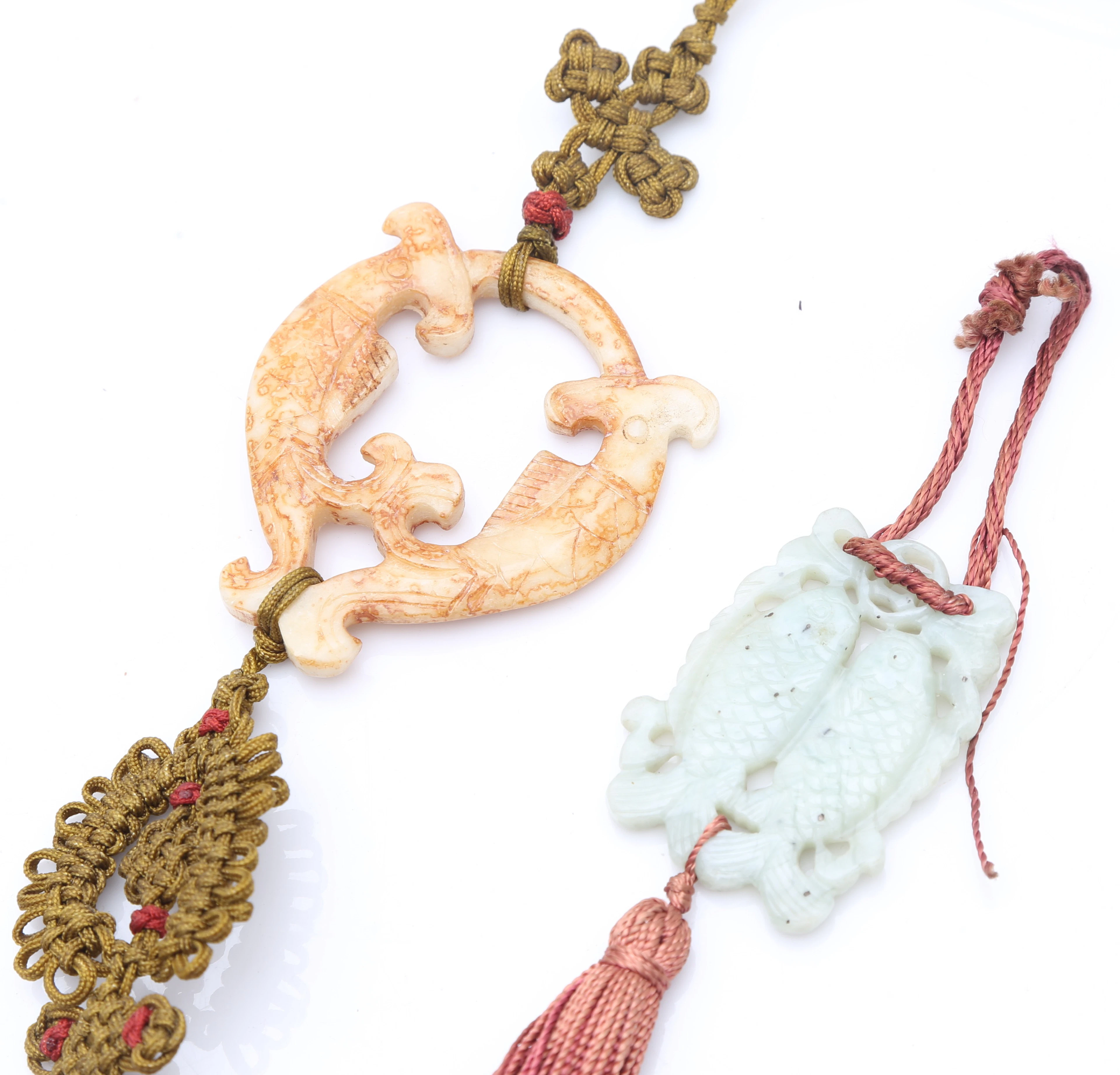 “Carps”, two Chinese amulets in carved jade, 20th Century.