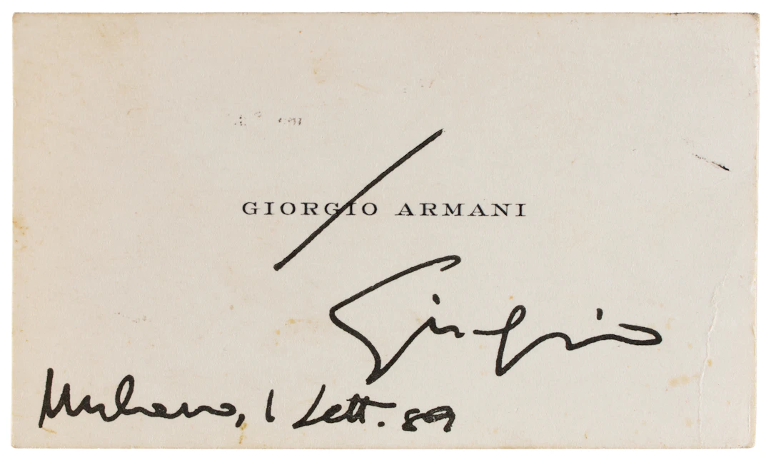 ARMANI, Giorgio (1934-). Biglietto da visita con firma autografa datata.