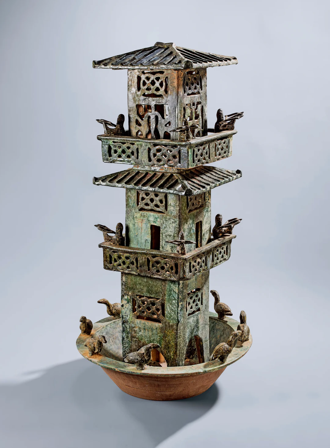 A GREEN-GLAZED POTTERY THREE-STOREY WATCHTOWER, HAN DYNASTY, 246 B.C.- 220
