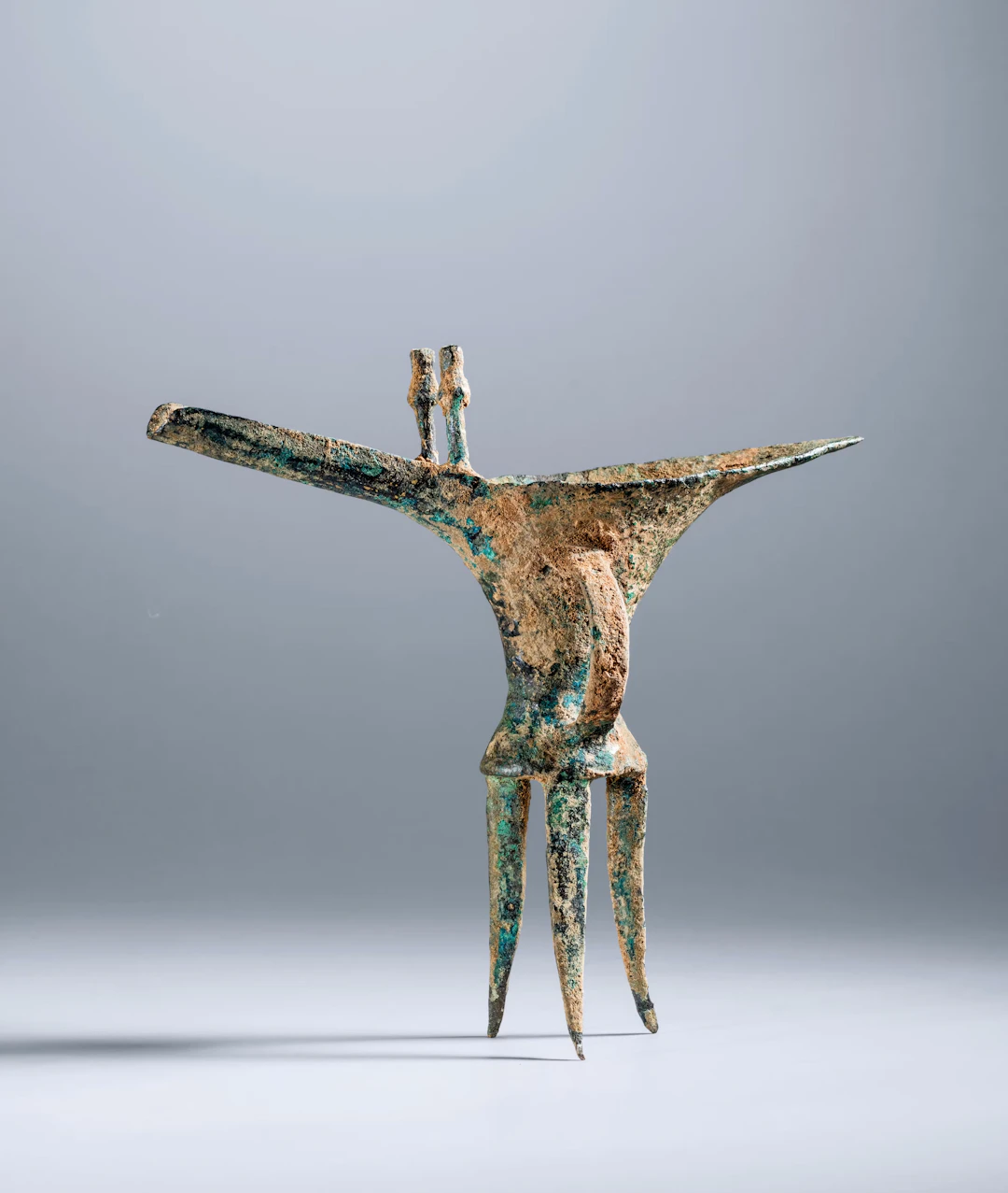 A SMALL BRONZE RITUAL TRIPOD WINE VESSEL, JUE, EARLY TO MID SHANG