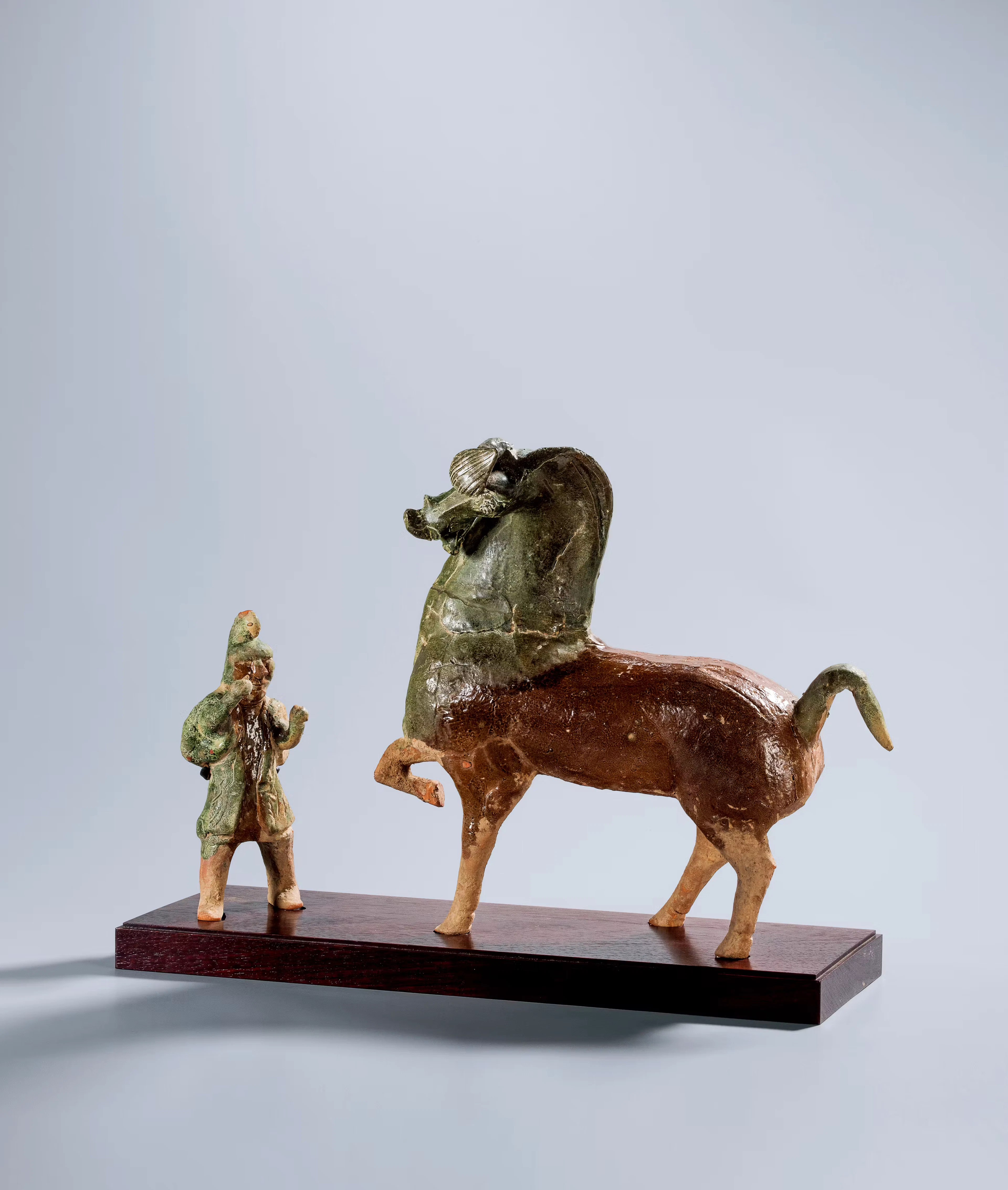 AN AMBER-AND-GREEN-GLAZED POTTERY HORSE WITH A GROOM, EASTERN HAN