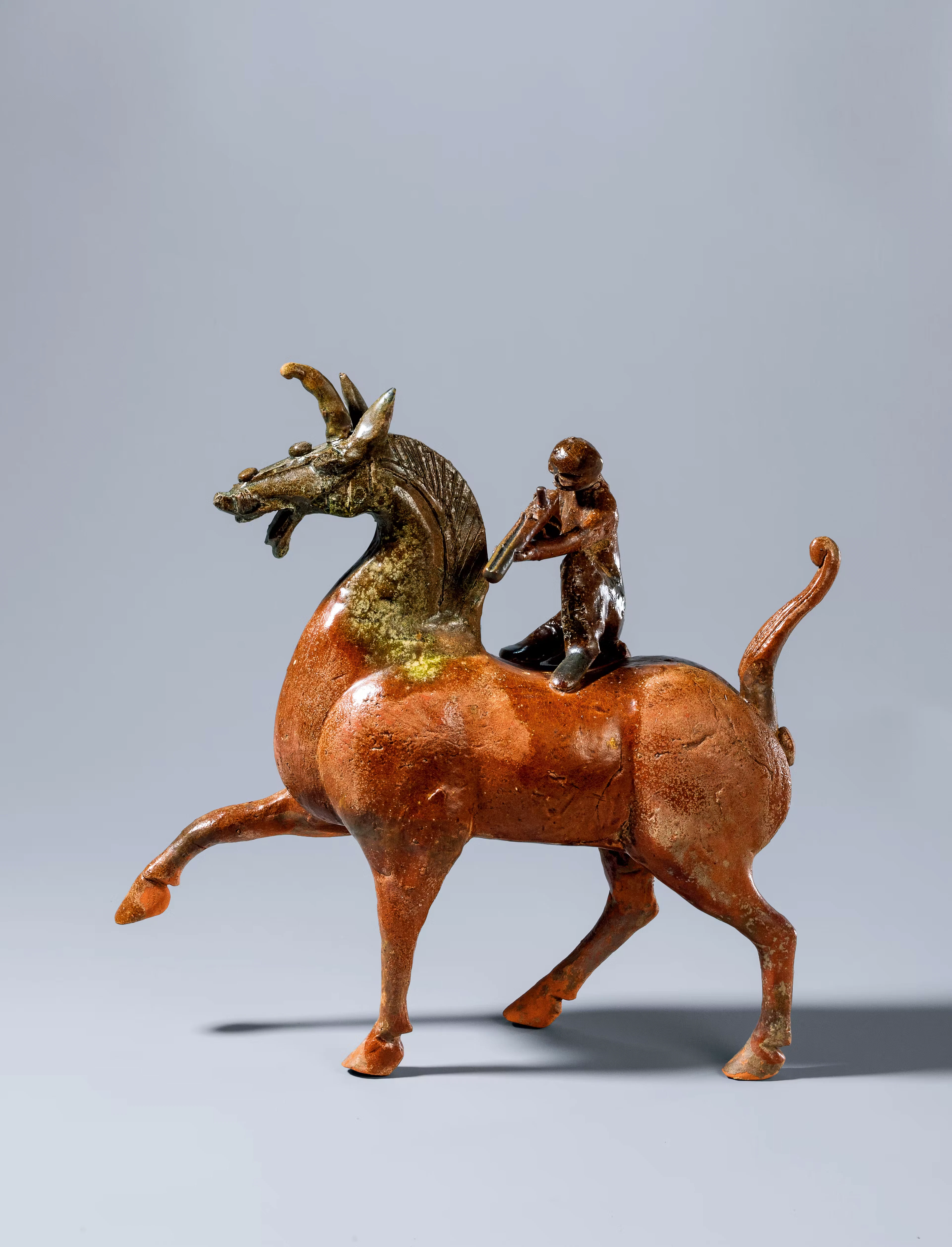 AN AMBER-AND-GREEN-GLAZED POTTERY HORSE AND ARCHER, EASTERN HAN DYNASTY