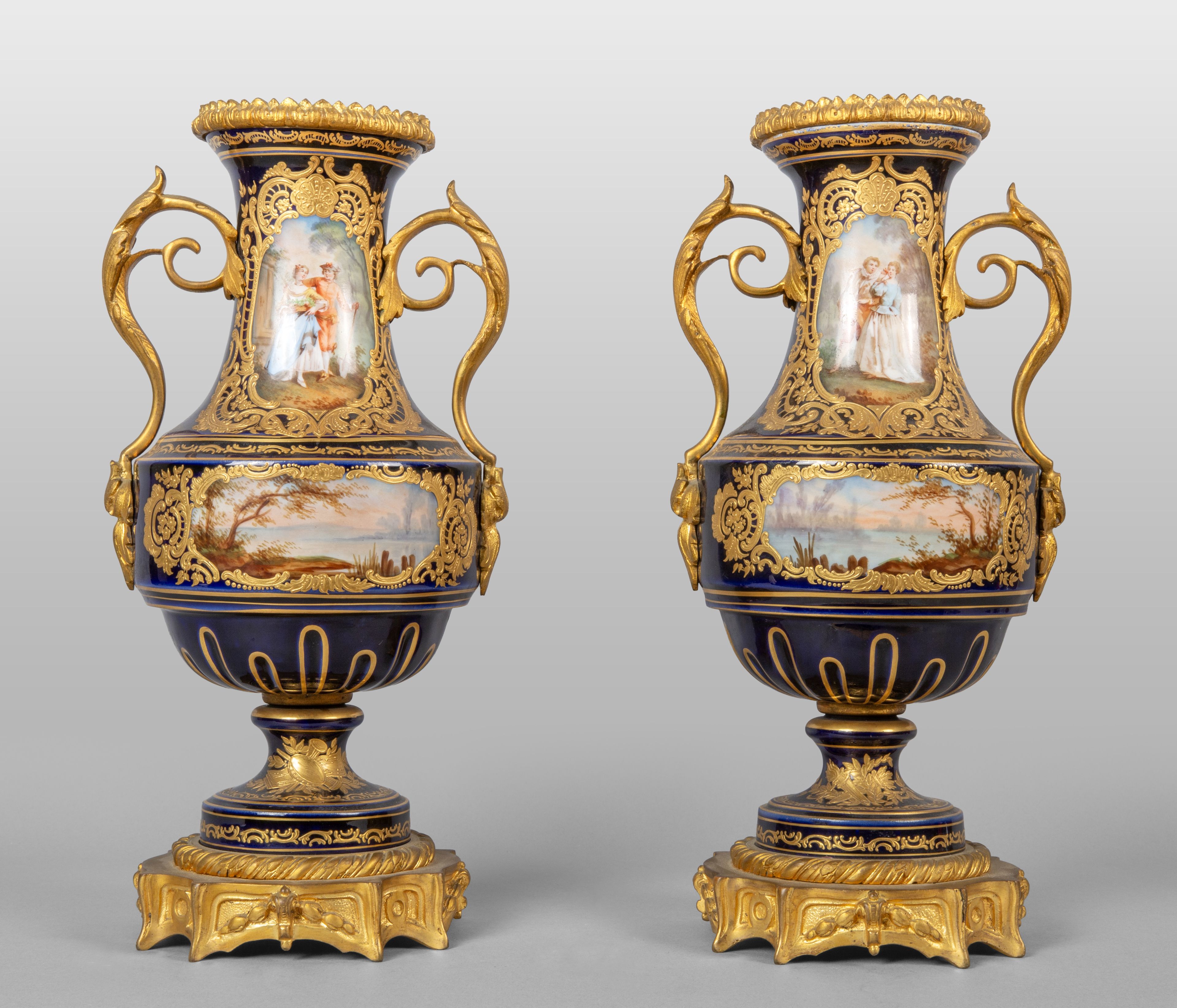 Coppia di vasi in porcellana blu e bronzo dorato decorati con paesaggi