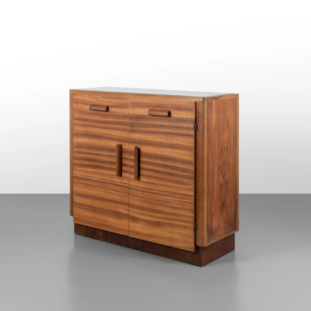 UNA CASSETTIERA, anni '40. Legno di zebrano, legno di noce, cristallo.