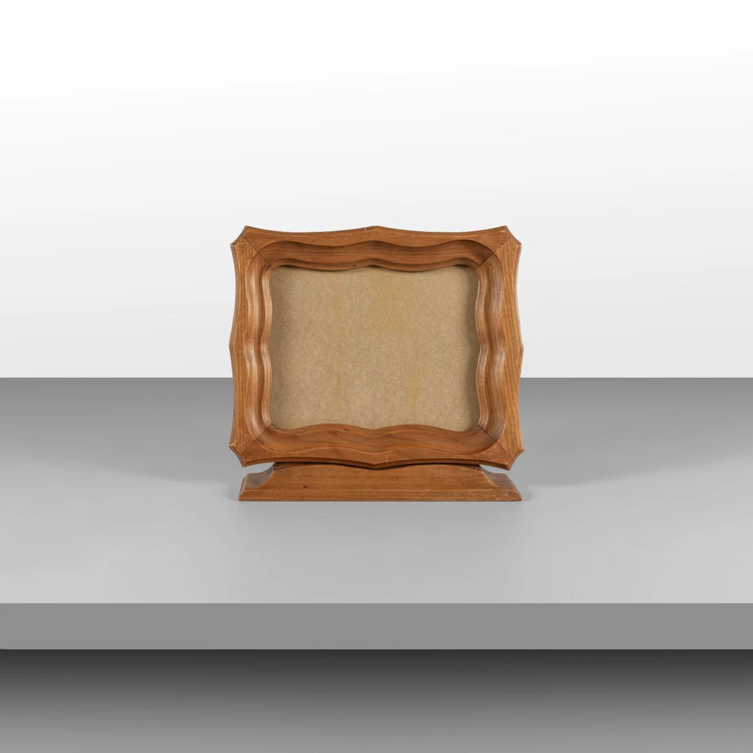 UN PORTARITRATTI, anni '50. Legno intagliato, cristallo. Posizionabile