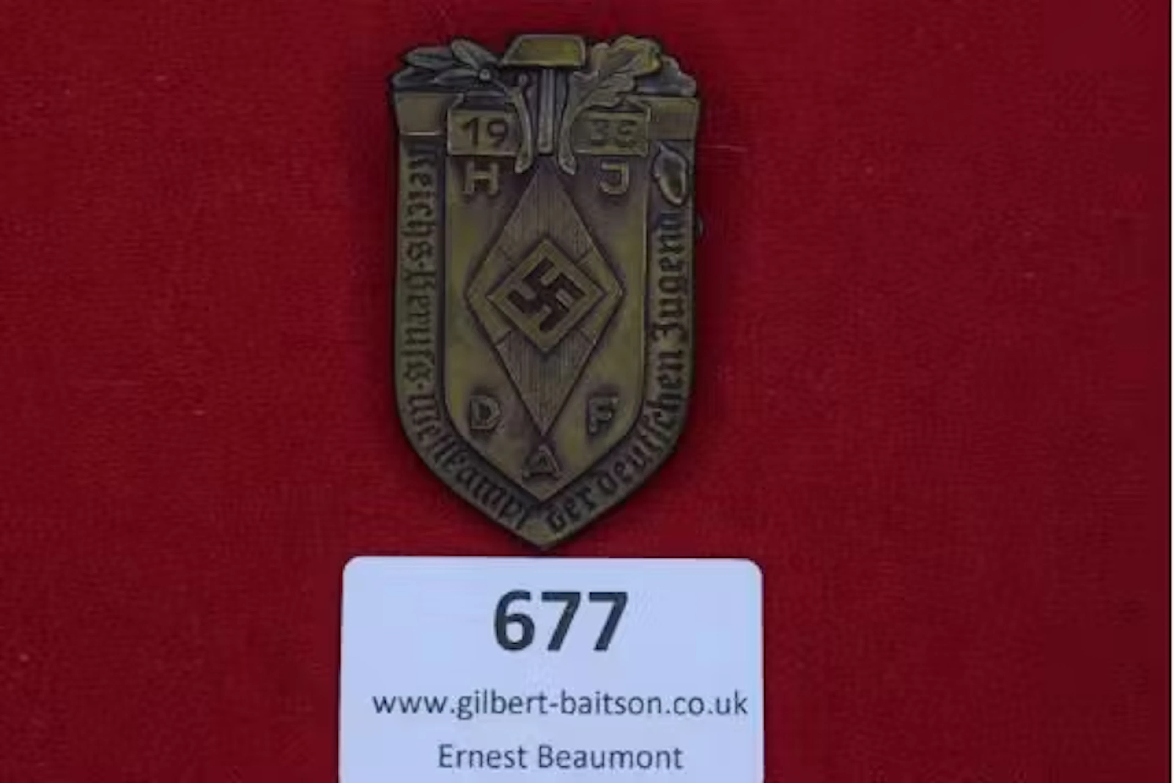 Shield-shaped bronze-coloured badge with oak leaves and hammer motif