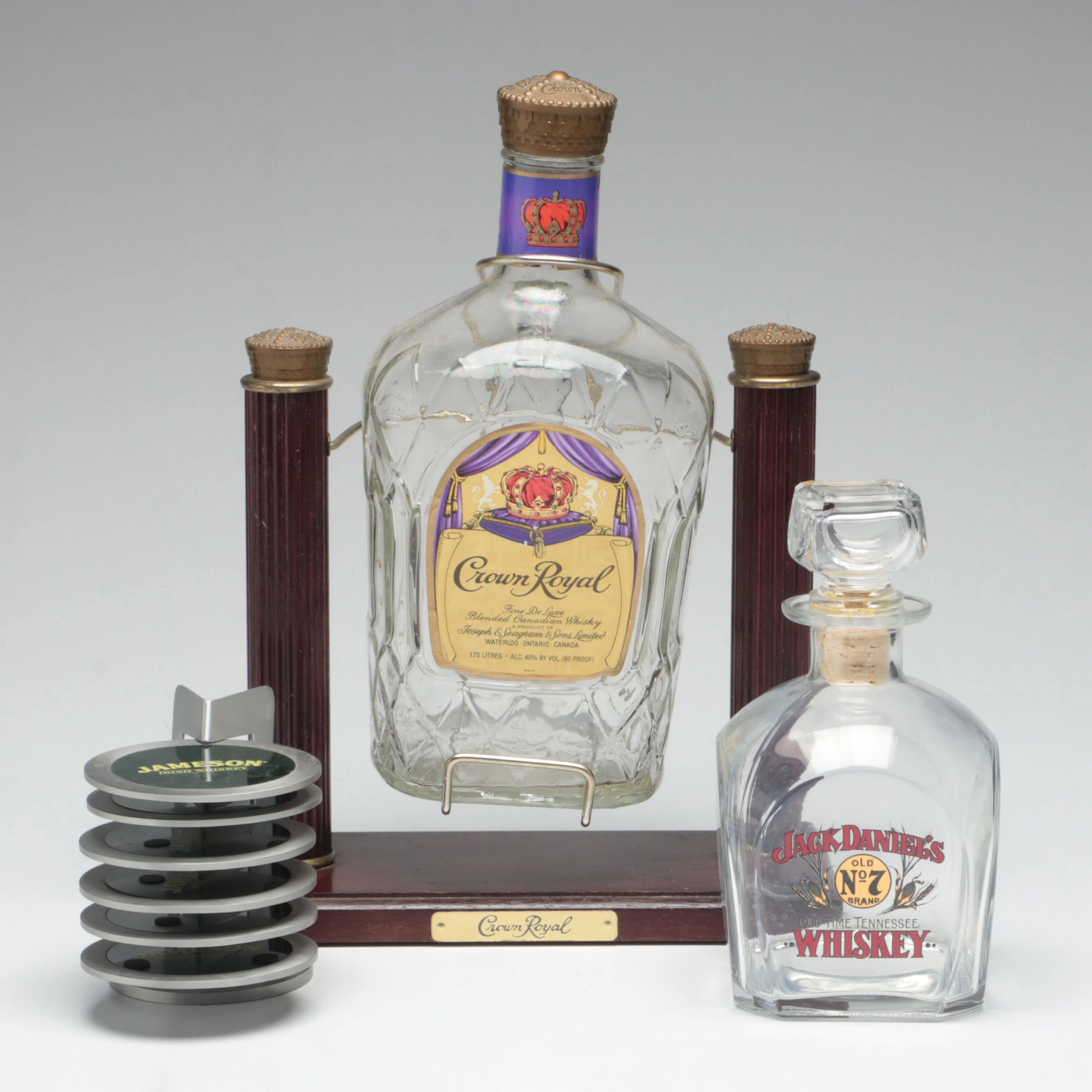 Crown Royal Glass Bottle in Cradle with Jack Daniels Bottle and Jameson