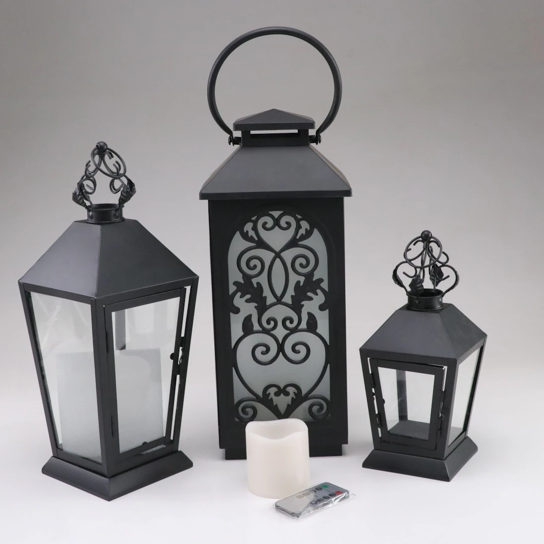 Three Decorative Metal Lanterns and a Faux Candle