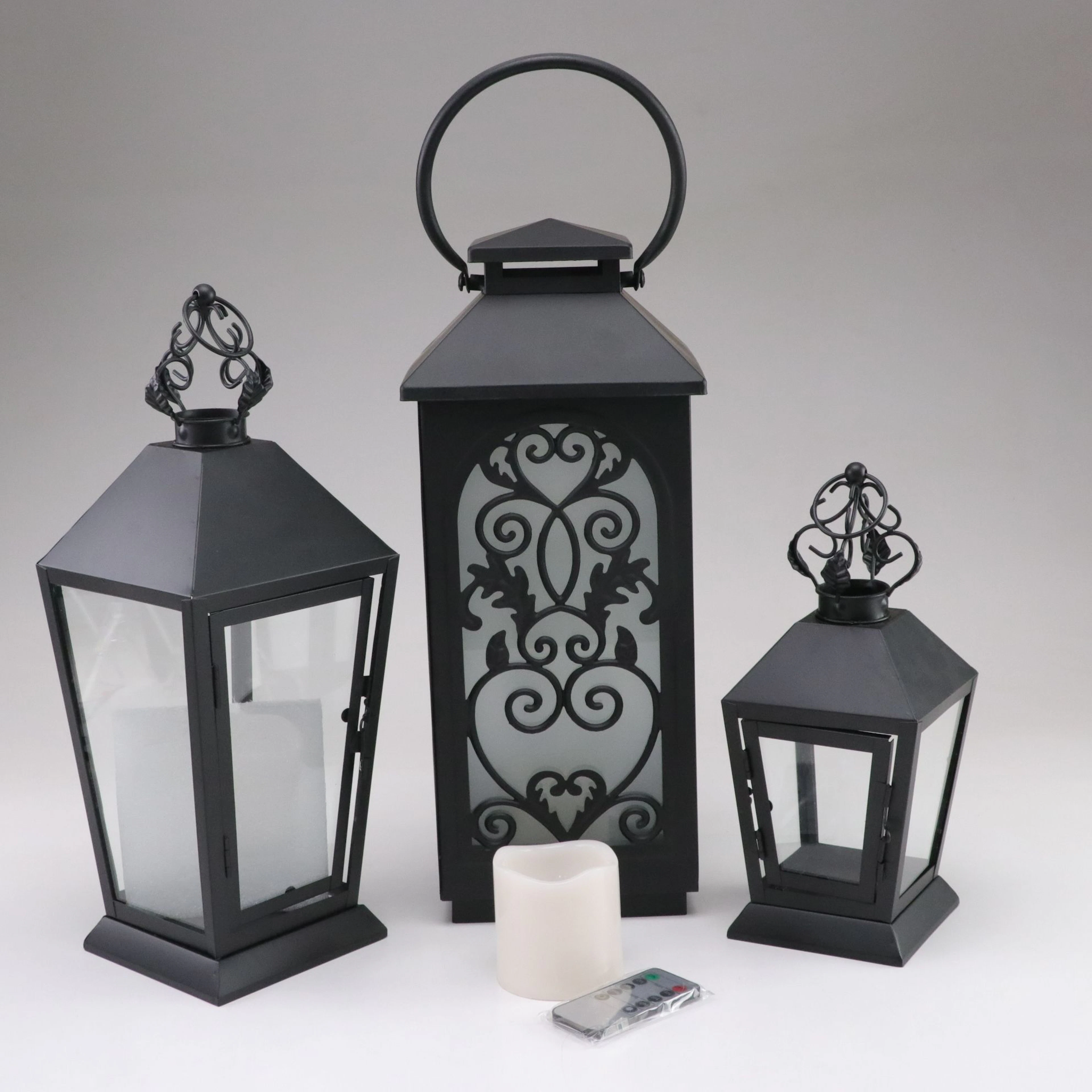 Three Decorative Metal Lanterns and a Faux Candle