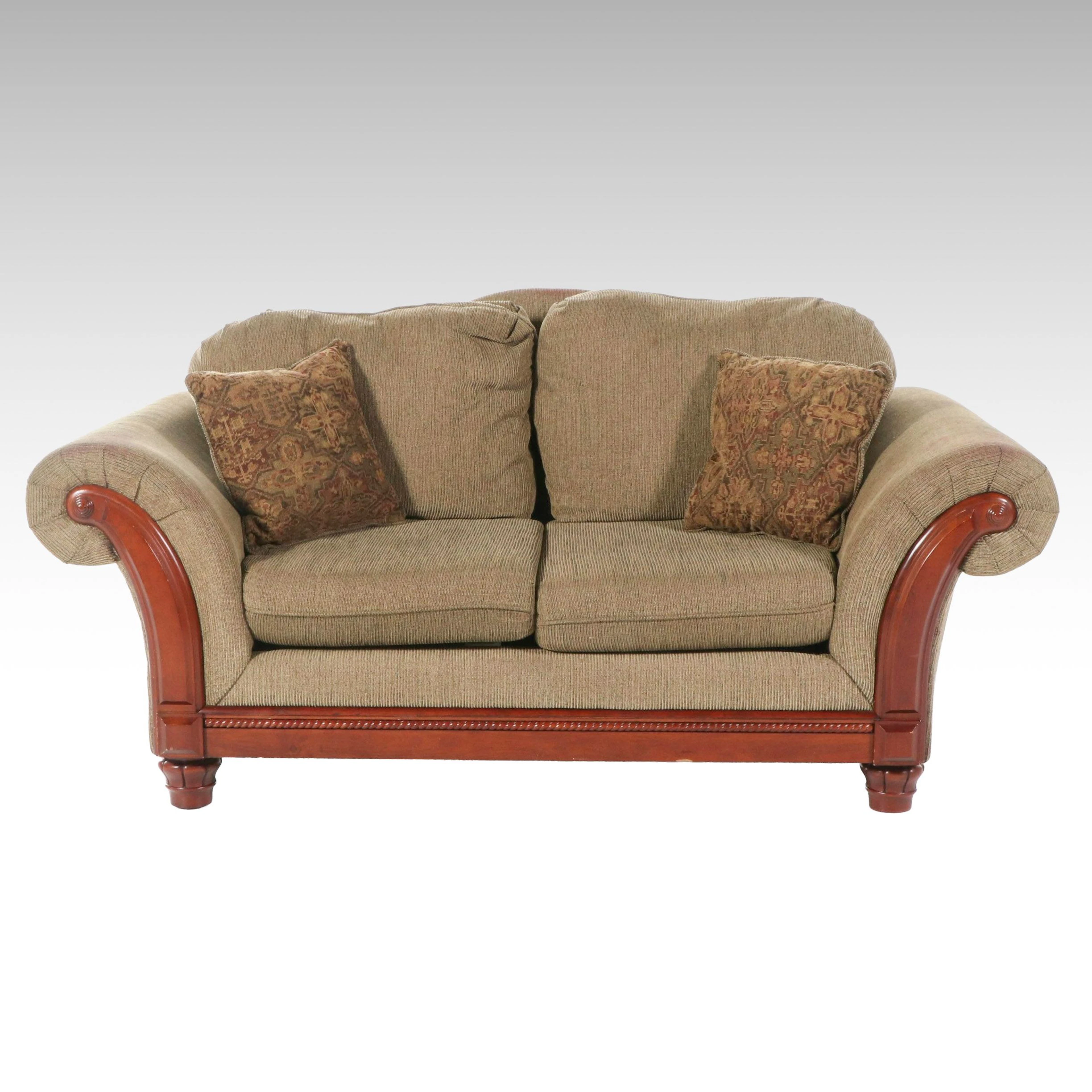 United Furniture Upholstered Loveseat with Wooden Arm Trims and Accent Pillows