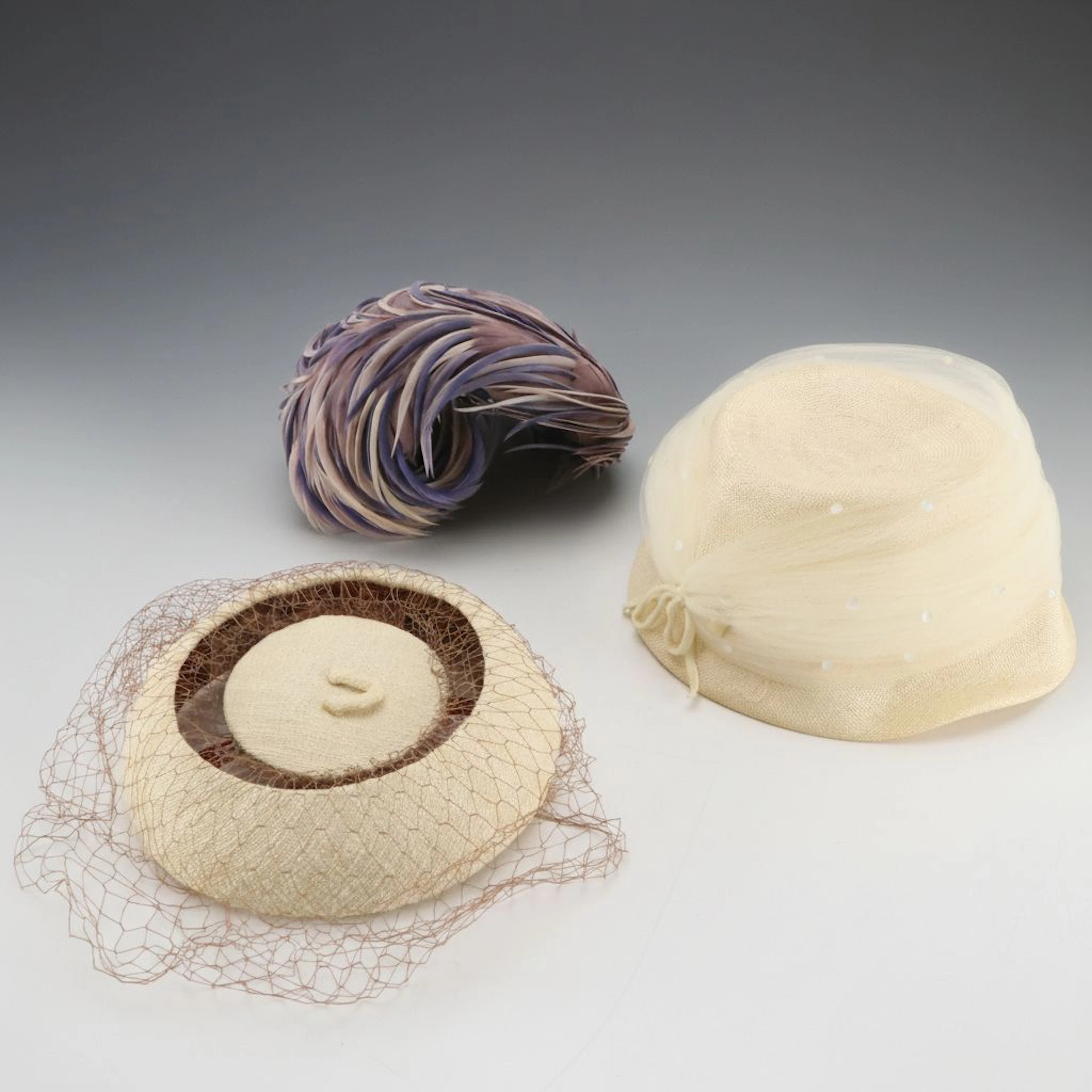 Feathered Crescent Hat, Veiled Pillbox Hat, and Tulle-Wrapped Cloche with Boxes