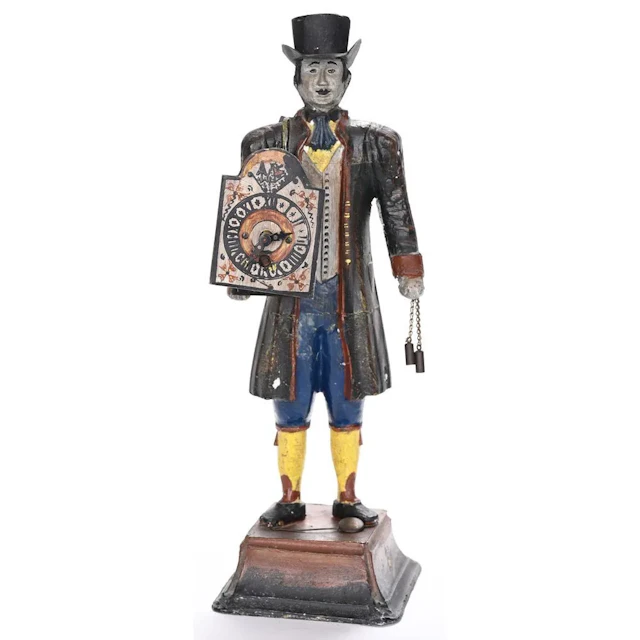 A painted cast-iron figure on a pedestal, holding a small clock mechanism