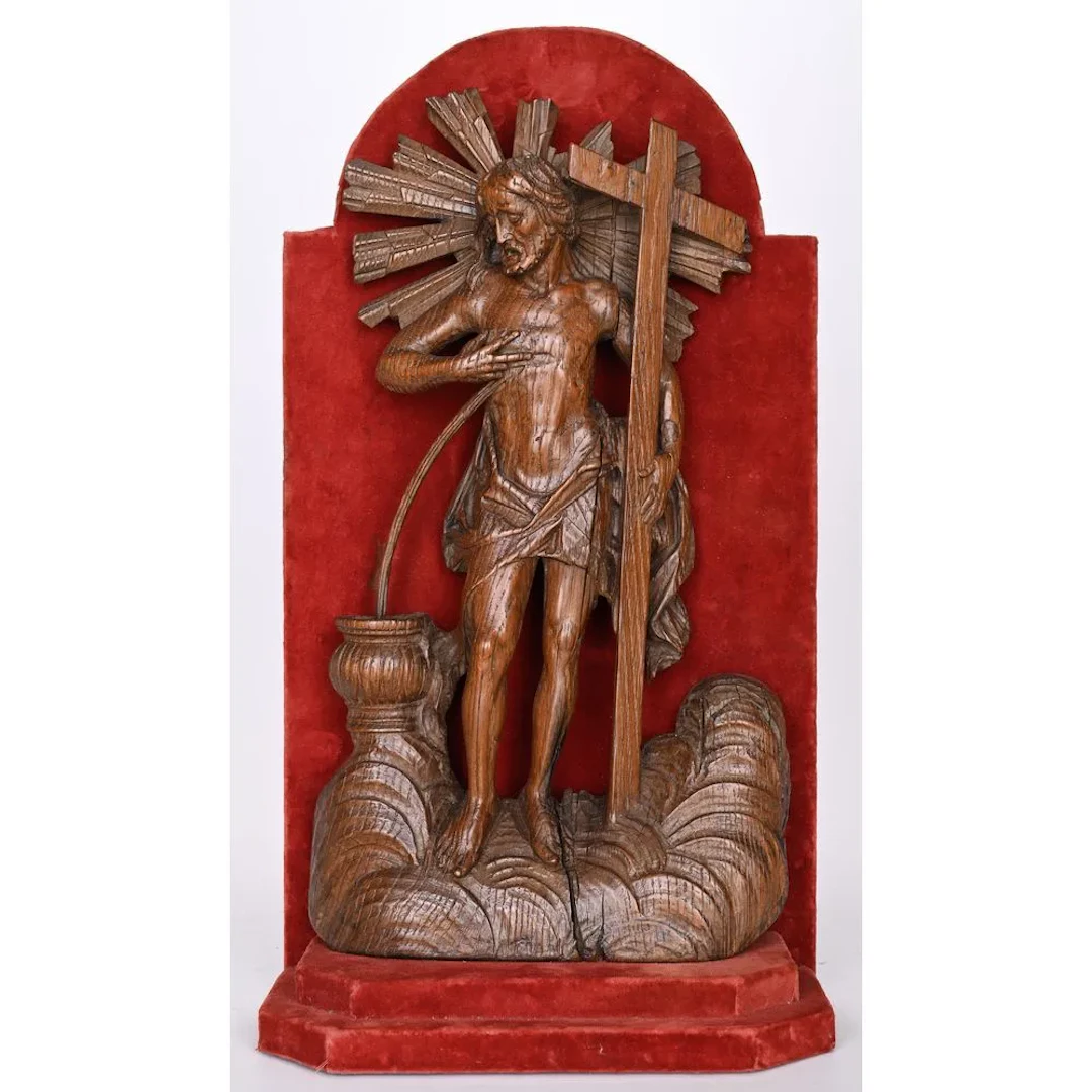 A patinated oak relief depicting Christ carrying the cross, with his