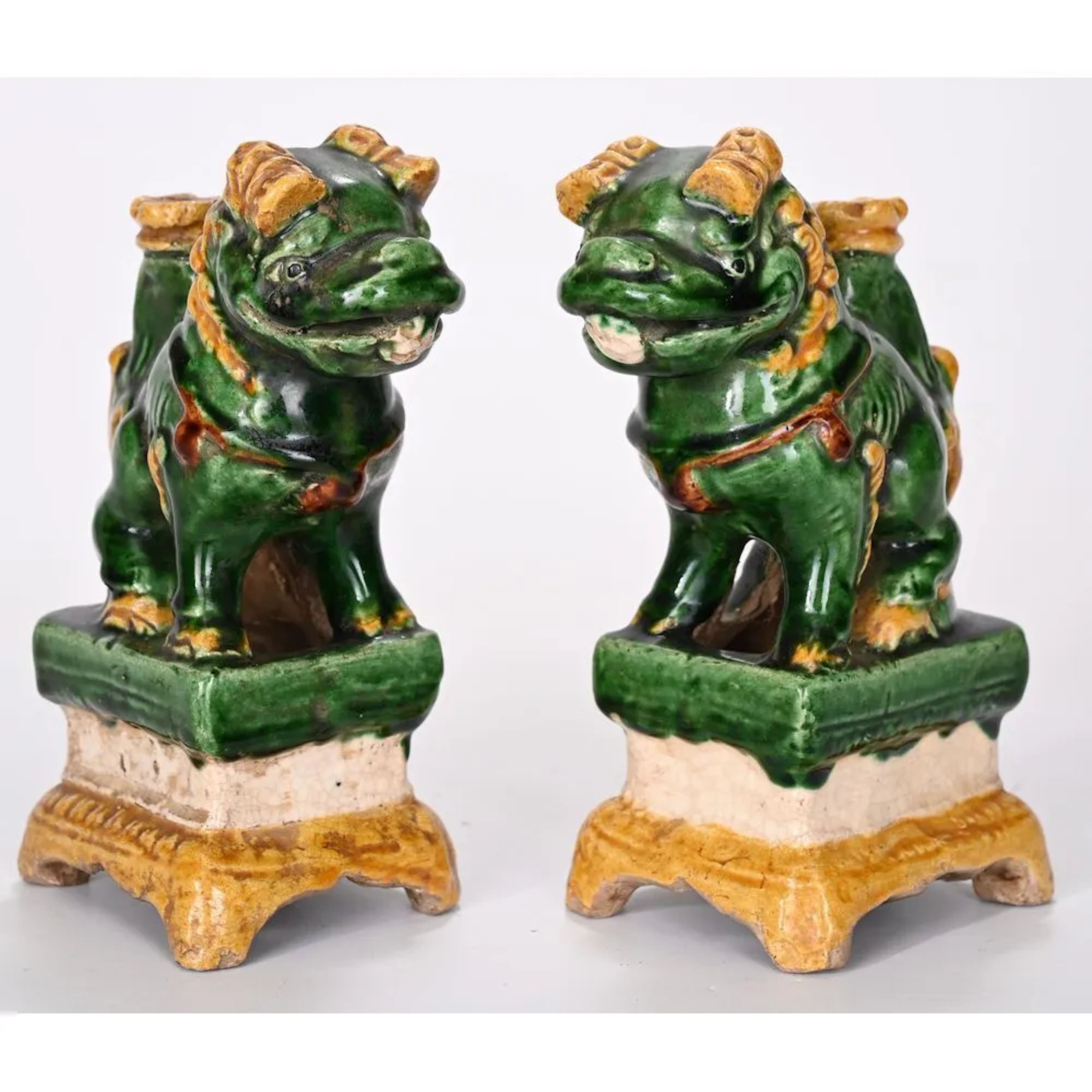 PAIR OF MAGOTS made of glazed ceramic. They depict Fô dogs on stelae.