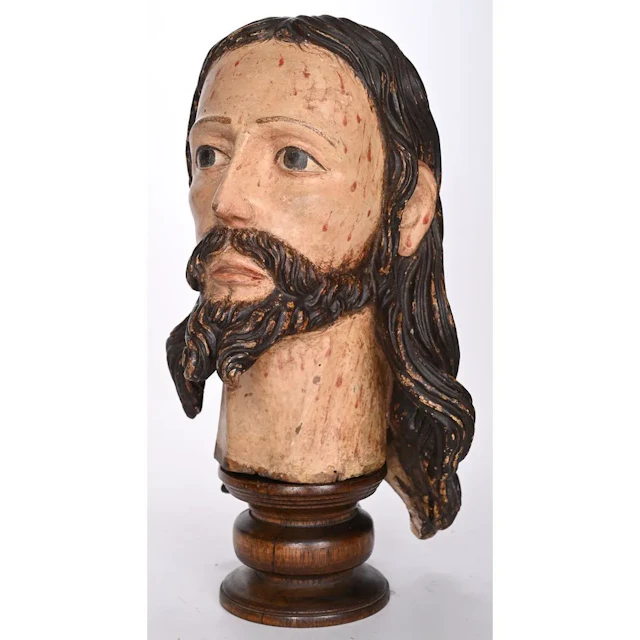 POLYCHROME WOODEN HEAD OF CHRIST. It rests on a turned wooden base.