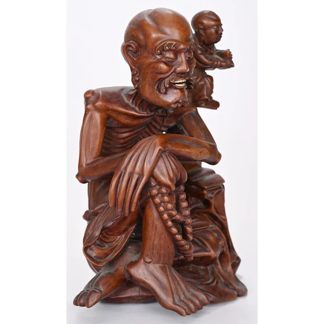 CURIOUS FIGURINE carved from exotic hardwood, depicting a skeletal