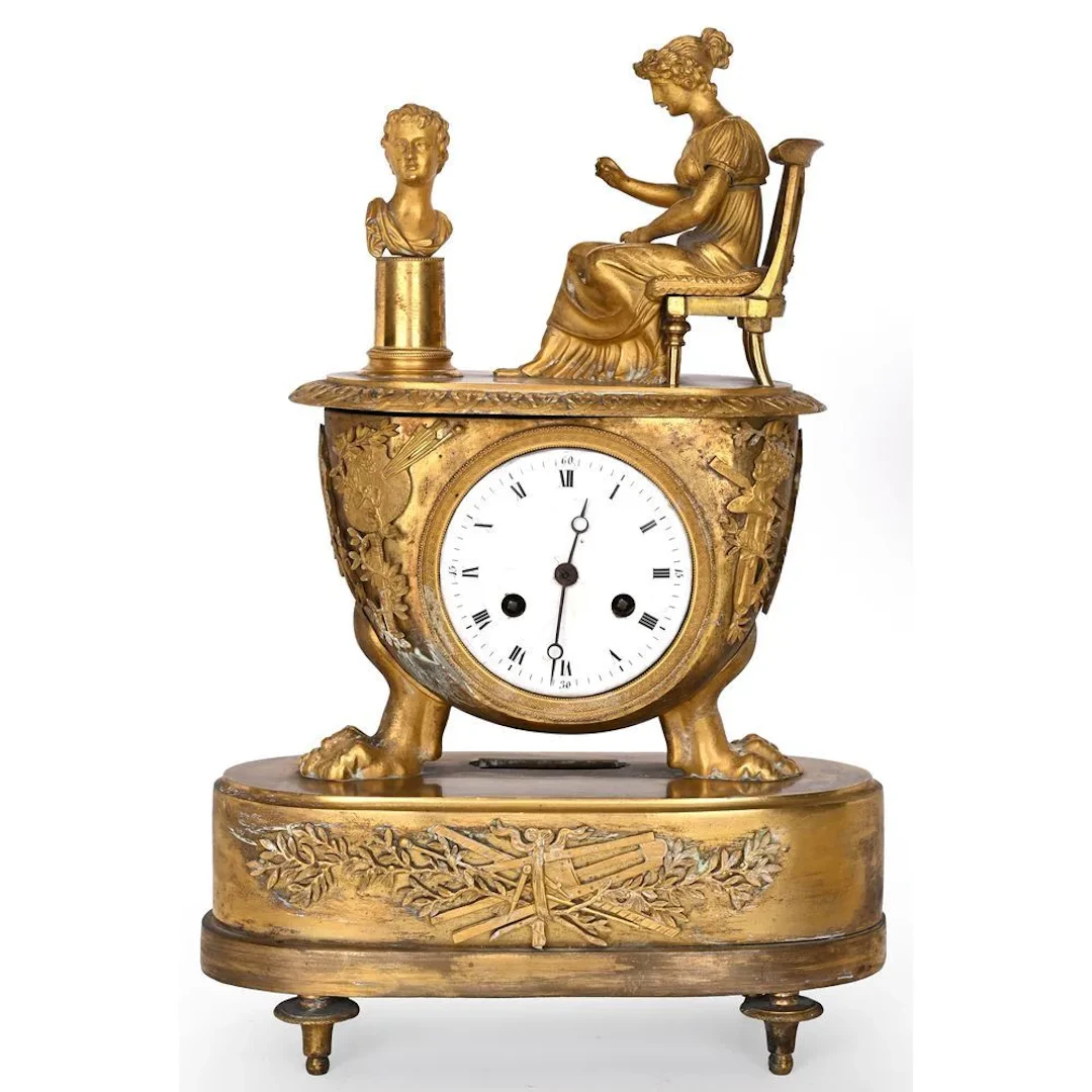 EMPIRE CLOCK in gilded bronze depicting a woman in classical style