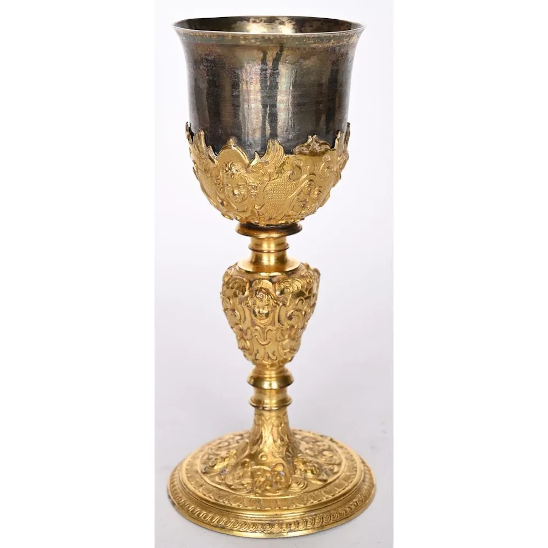 A gilded bronze chalice, likely vermeil, decorated with cherub heads