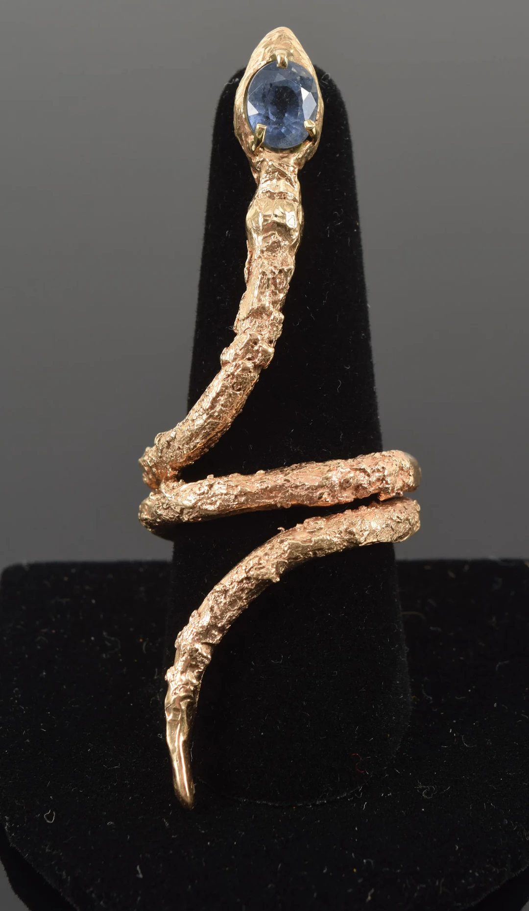 Large 14K gold coiled snake form ring with aquamarine set head. Textured
