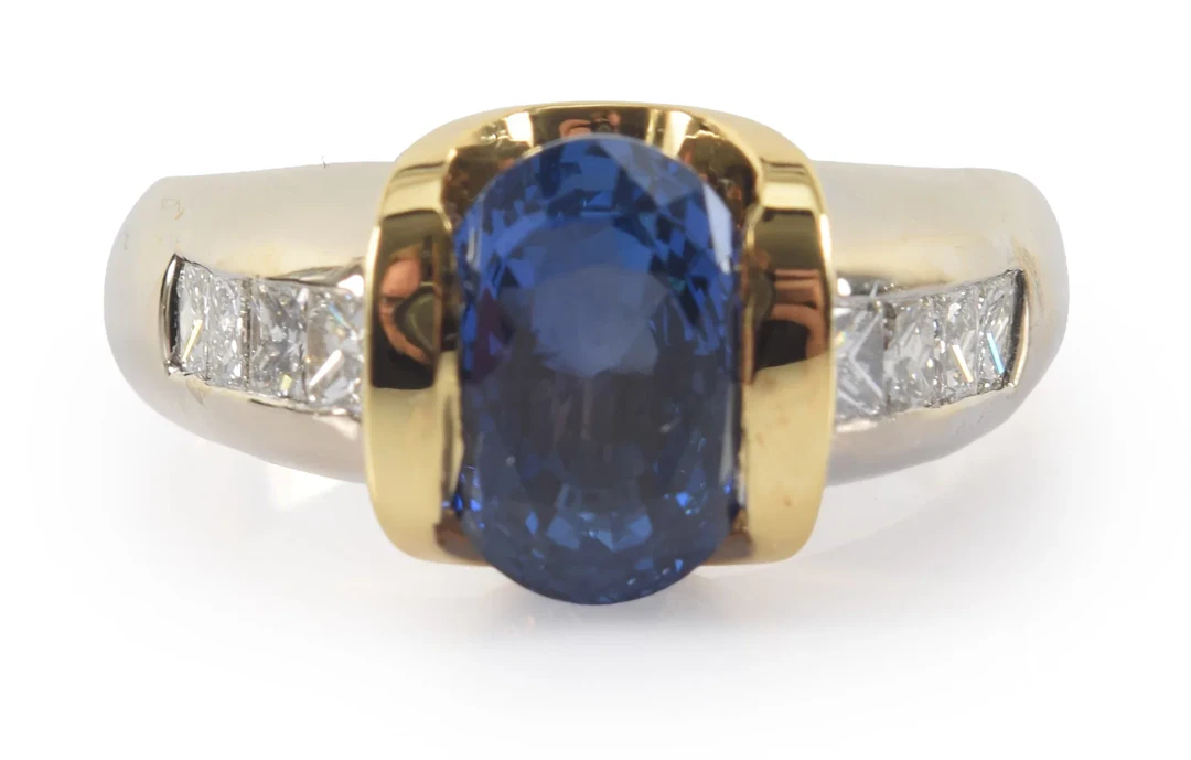 14K gold sapphire and diamond ring. Oval cut central sapphire measures