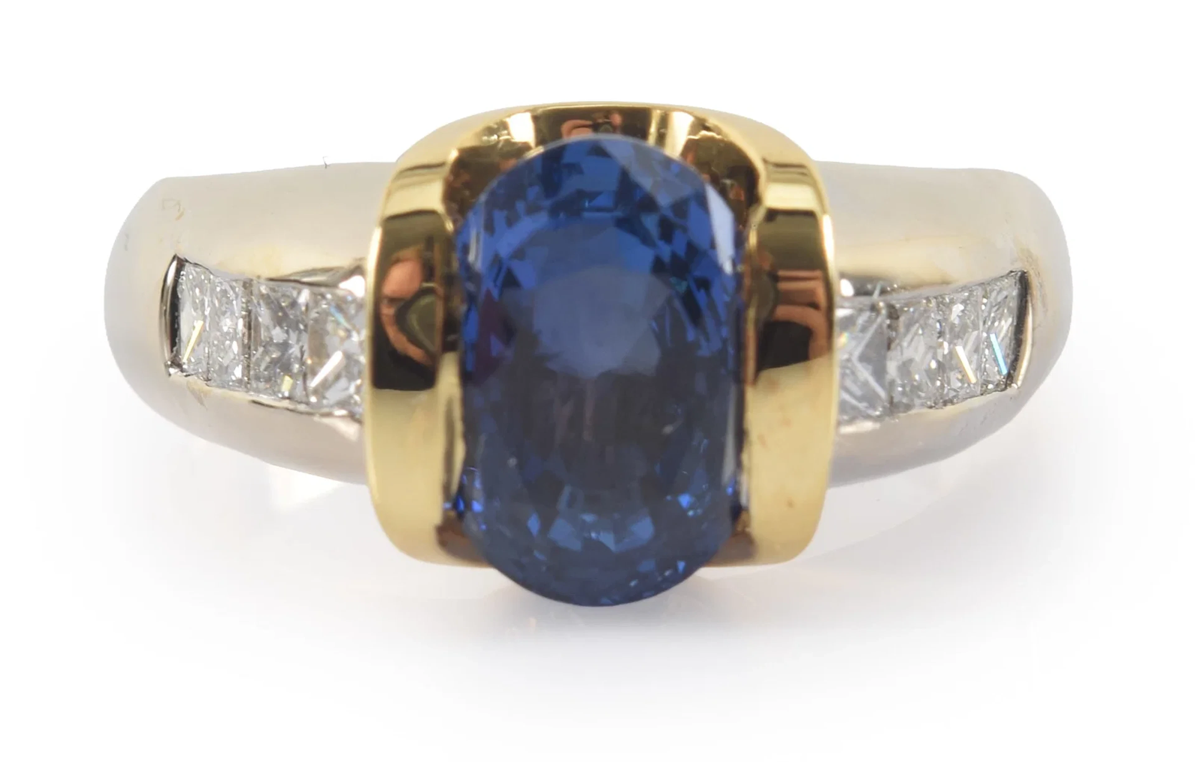 14K gold sapphire and diamond ring. Oval cut central sapphire measures