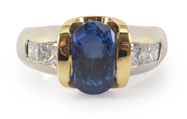 14K gold sapphire and diamond ring. Oval cut central sapphire measures