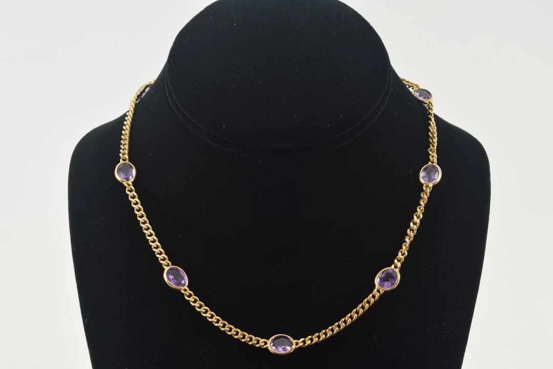 18K gold amethyst necklace. 9 oval cut amethysts, each about 7.5 x