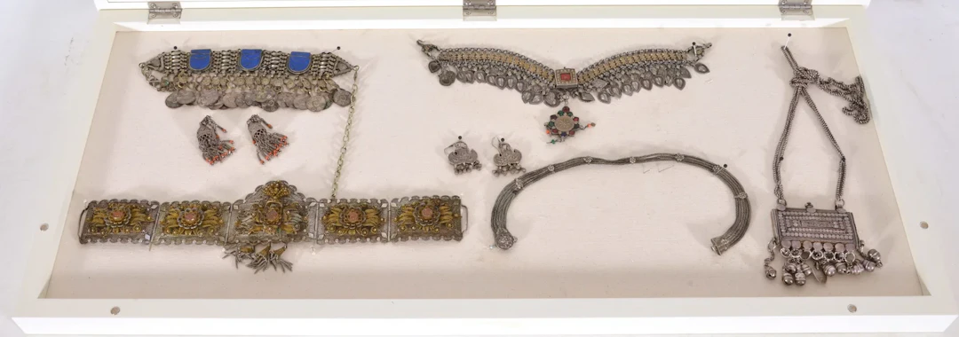 Collection of silver ethnographic jewelry in vitrine case, some with