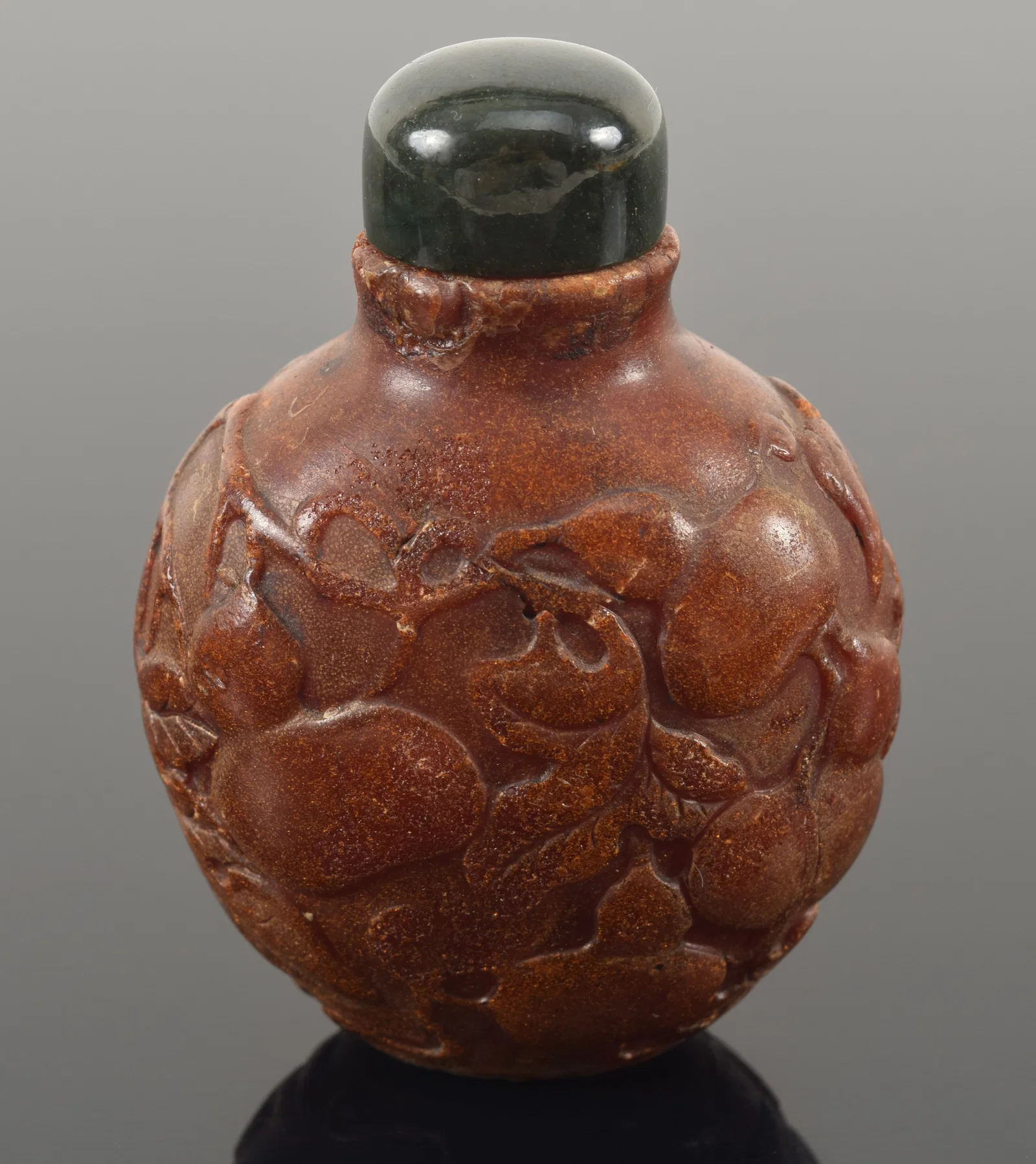 19th century Chinese carved amber snuff bottle. Allover fruit decoration.