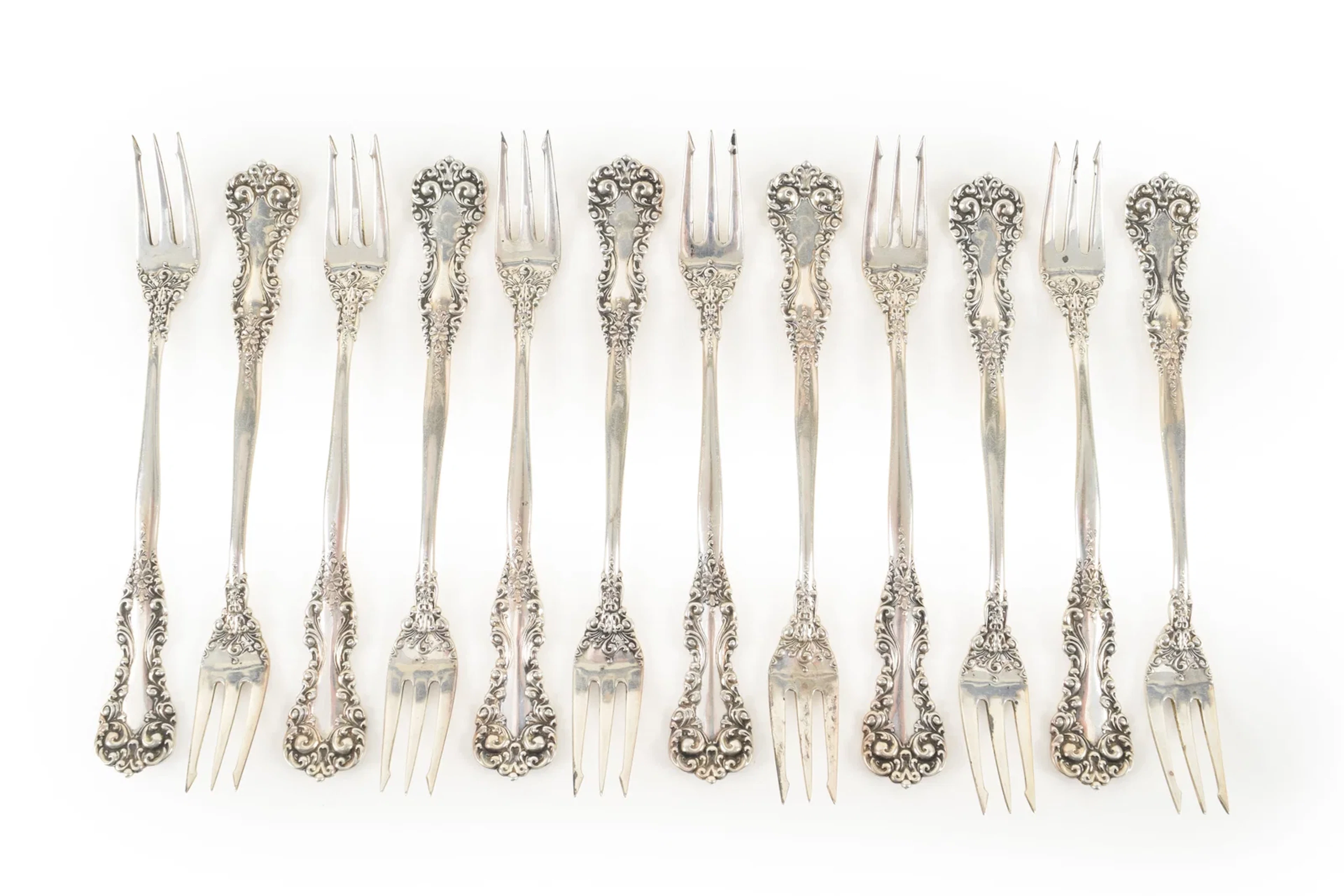 Set of 12 Sterling silver oyster forks with floral decoration. Length