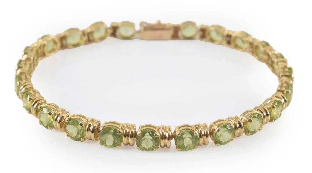 14K gold peridot line bracelet. 23 round cut stones, each measuring