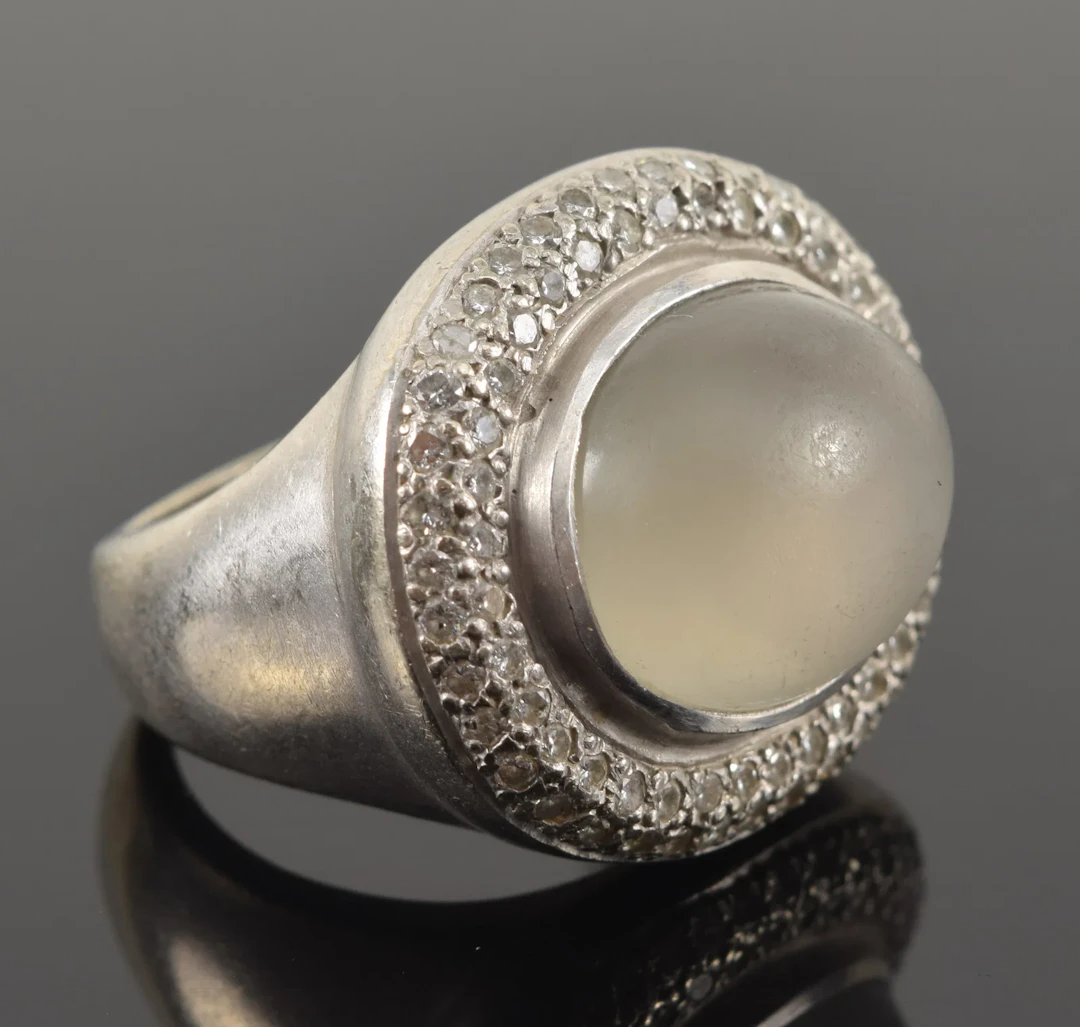 14K white gold grey moonstone and diamond mounted ring. Domed oval