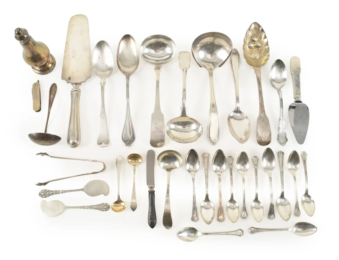 Assortment of silver and silver plated utensils.