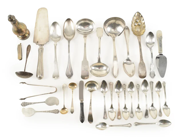 Assortment of silver and silver plated utensils.