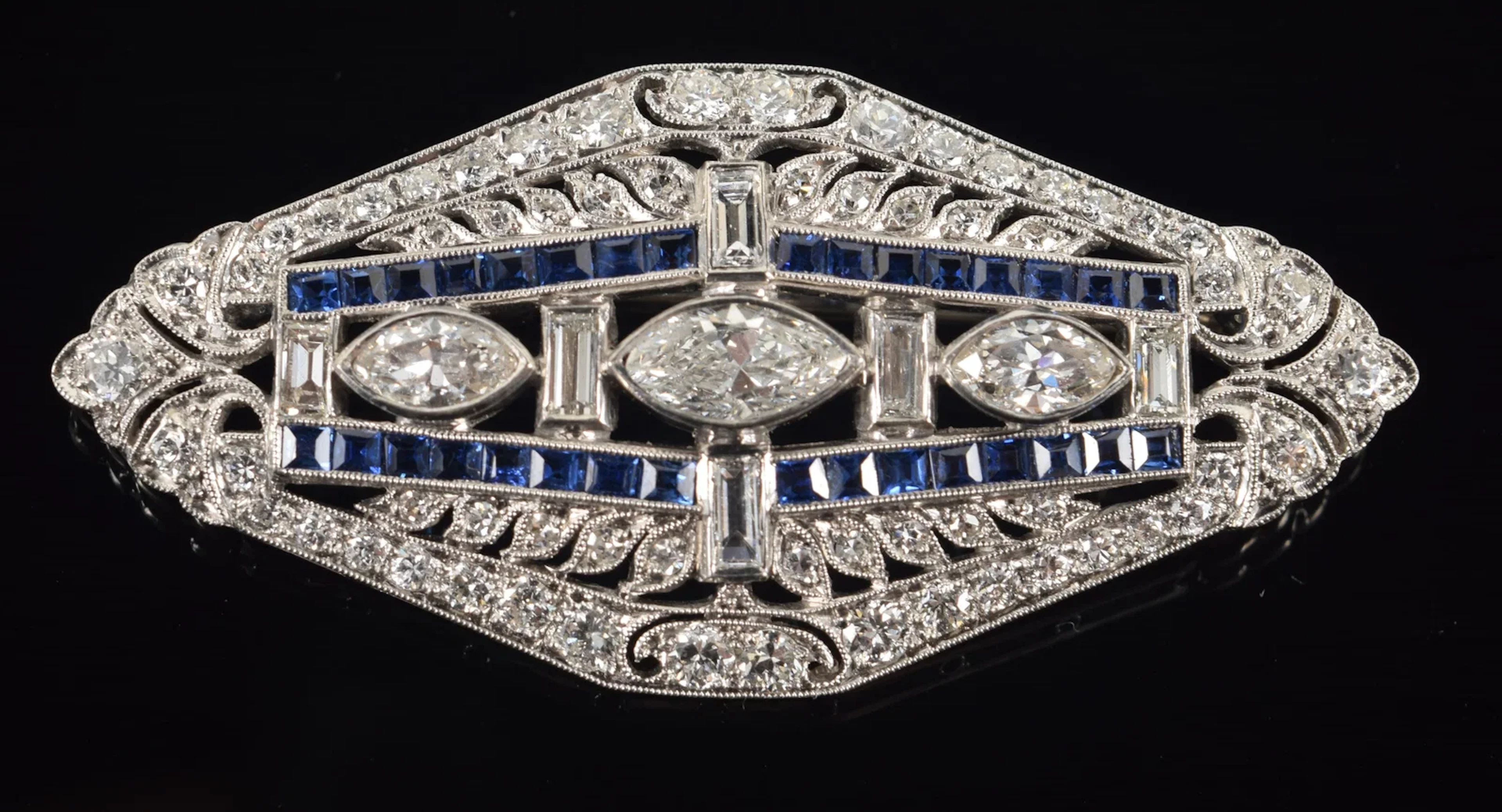 Art Deco 18K white gold diamond and sapphire brooch. Center set with