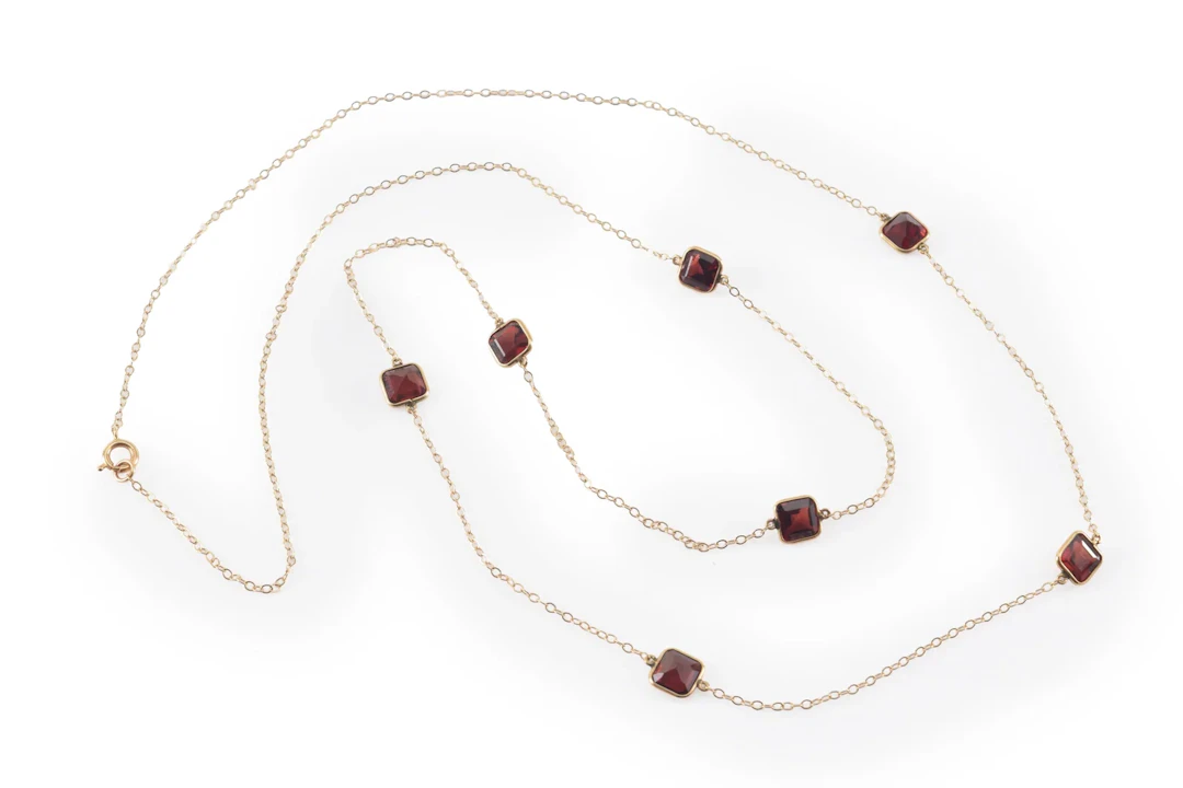 14K gold garnet mounted necklace. Long chain set with 7 square cut