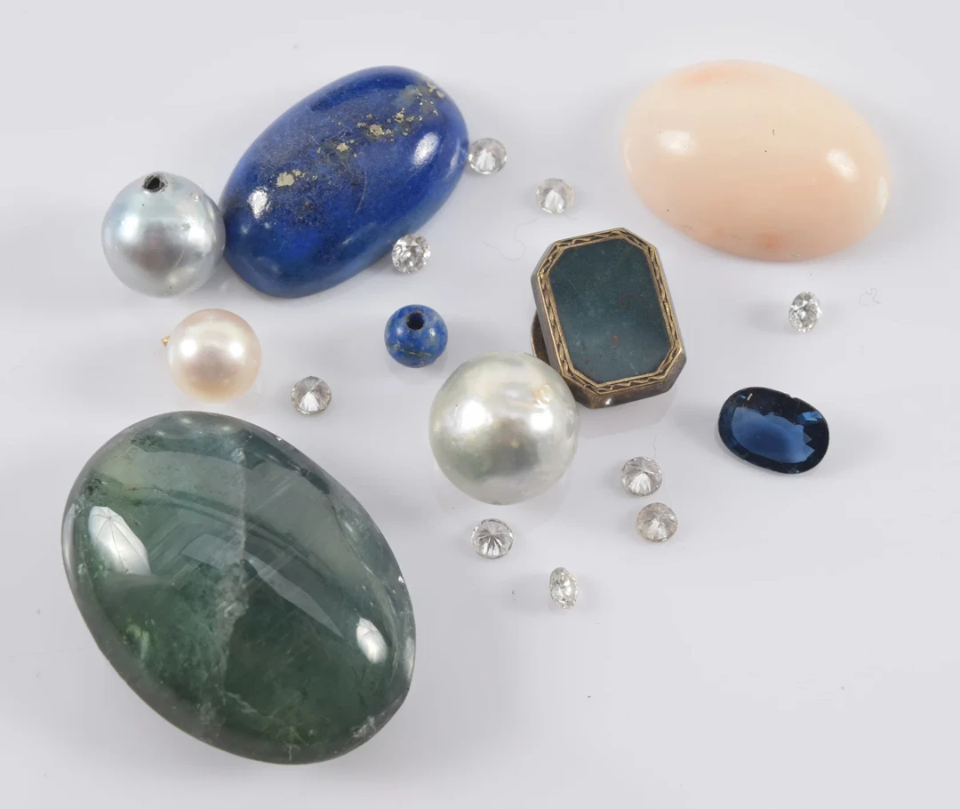 Assortment of loose gem stones, including diamonds, lapis, sapphire