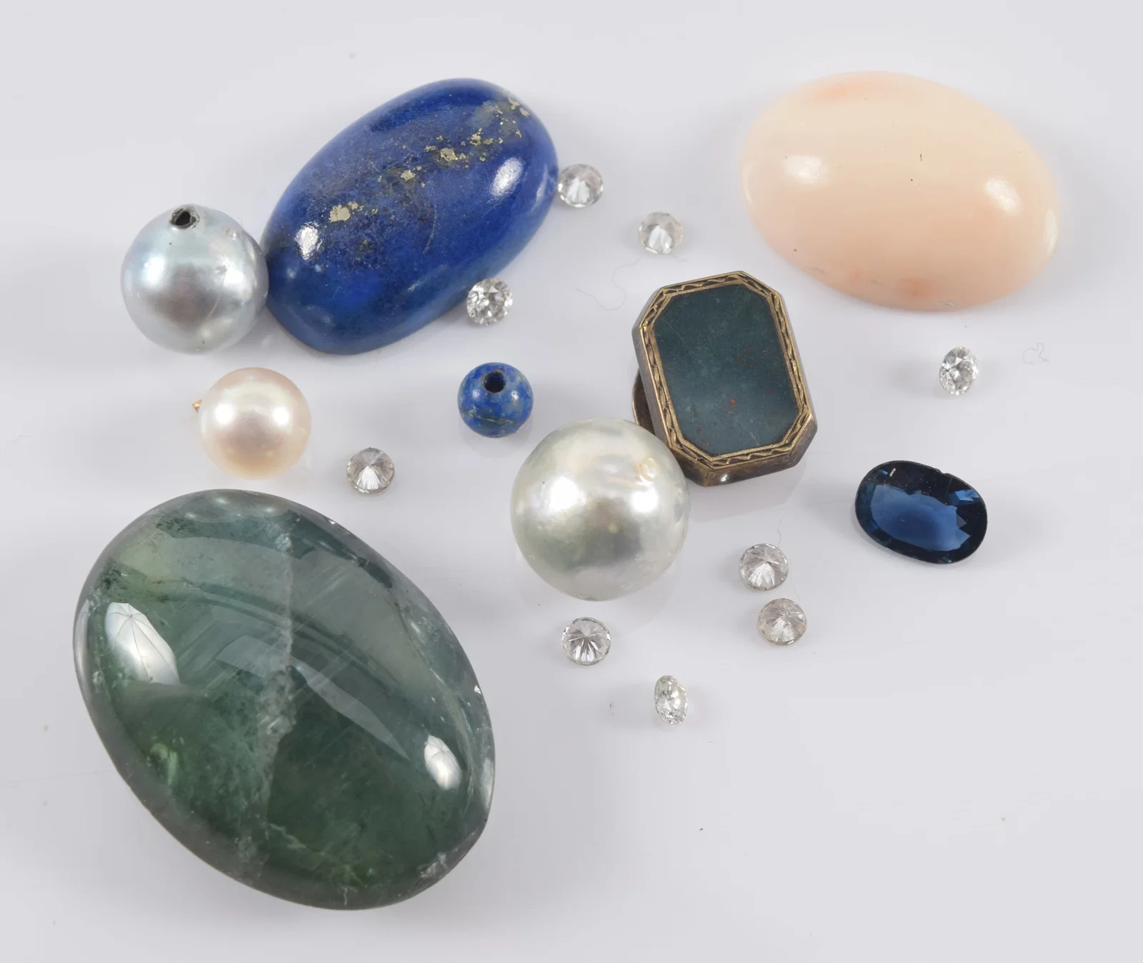 Assortment of loose gem stones, including diamonds, lapis, sapphire