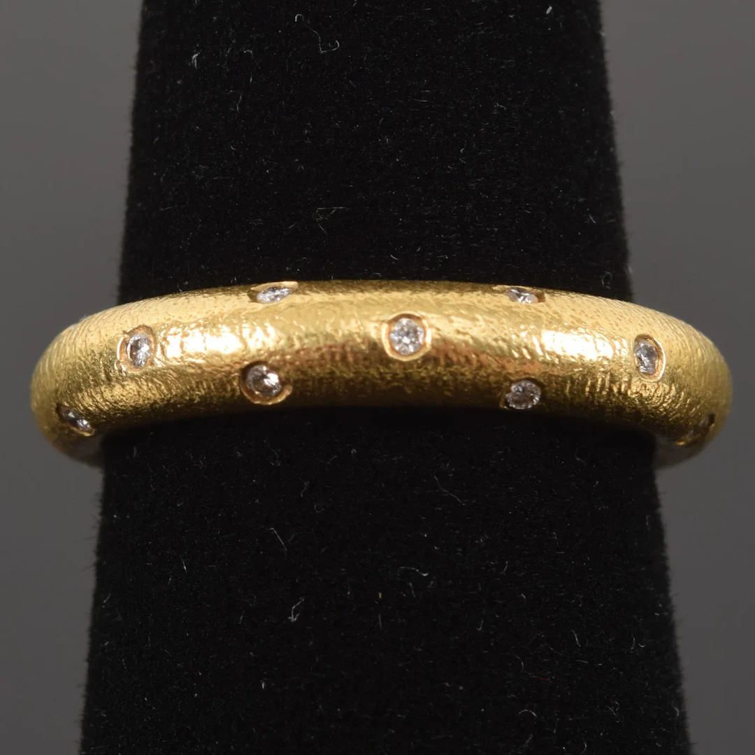 18K gold diamond studded eternity band. Ring size 6.5. Marked 18K