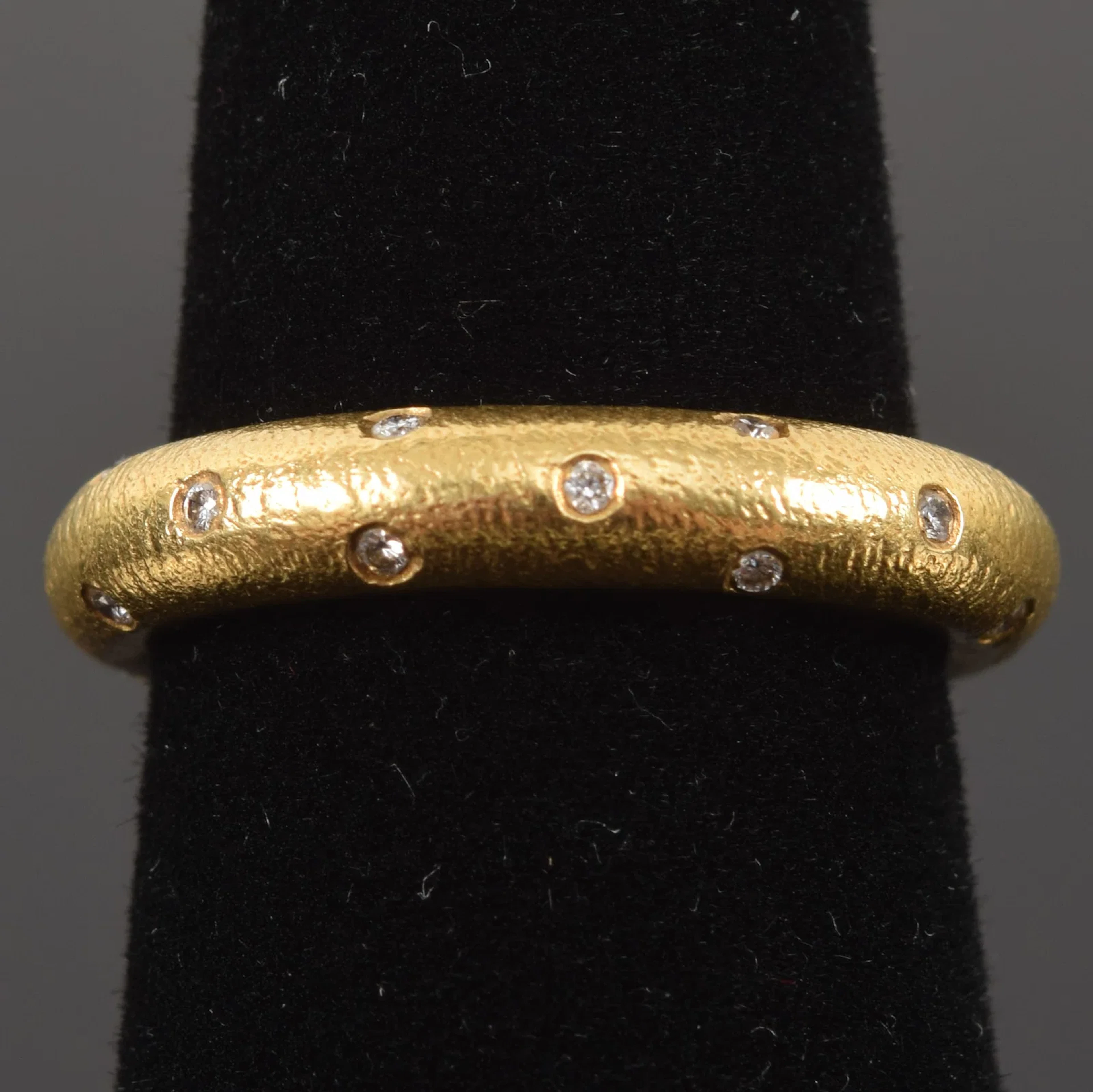 18K gold diamond studded eternity band. Ring size 6.5. Marked 18K