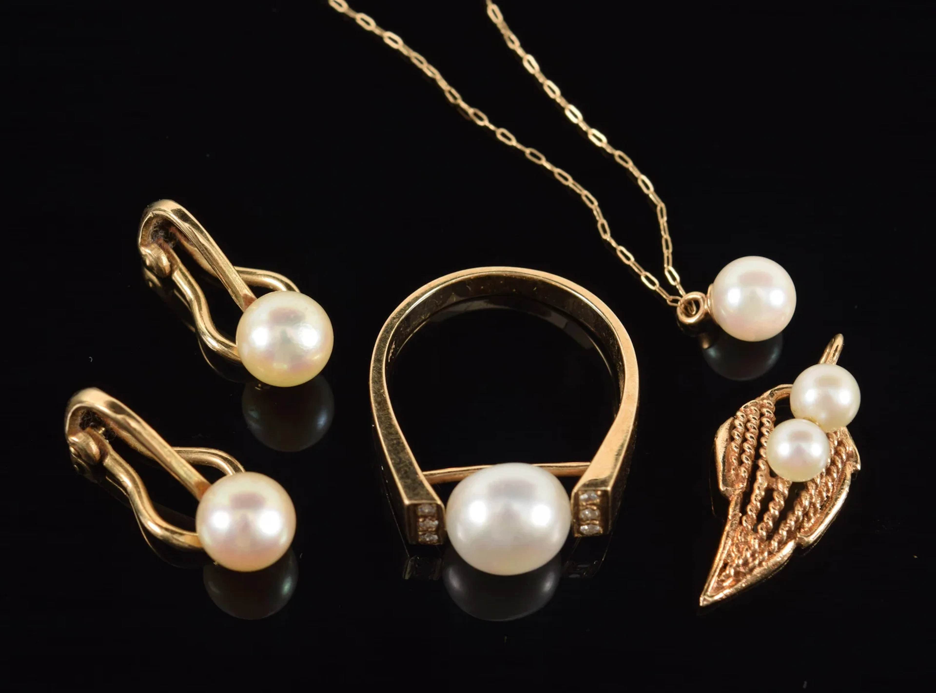 Lot of gold pearl jewelry. To include: pair of clip earrings, ring