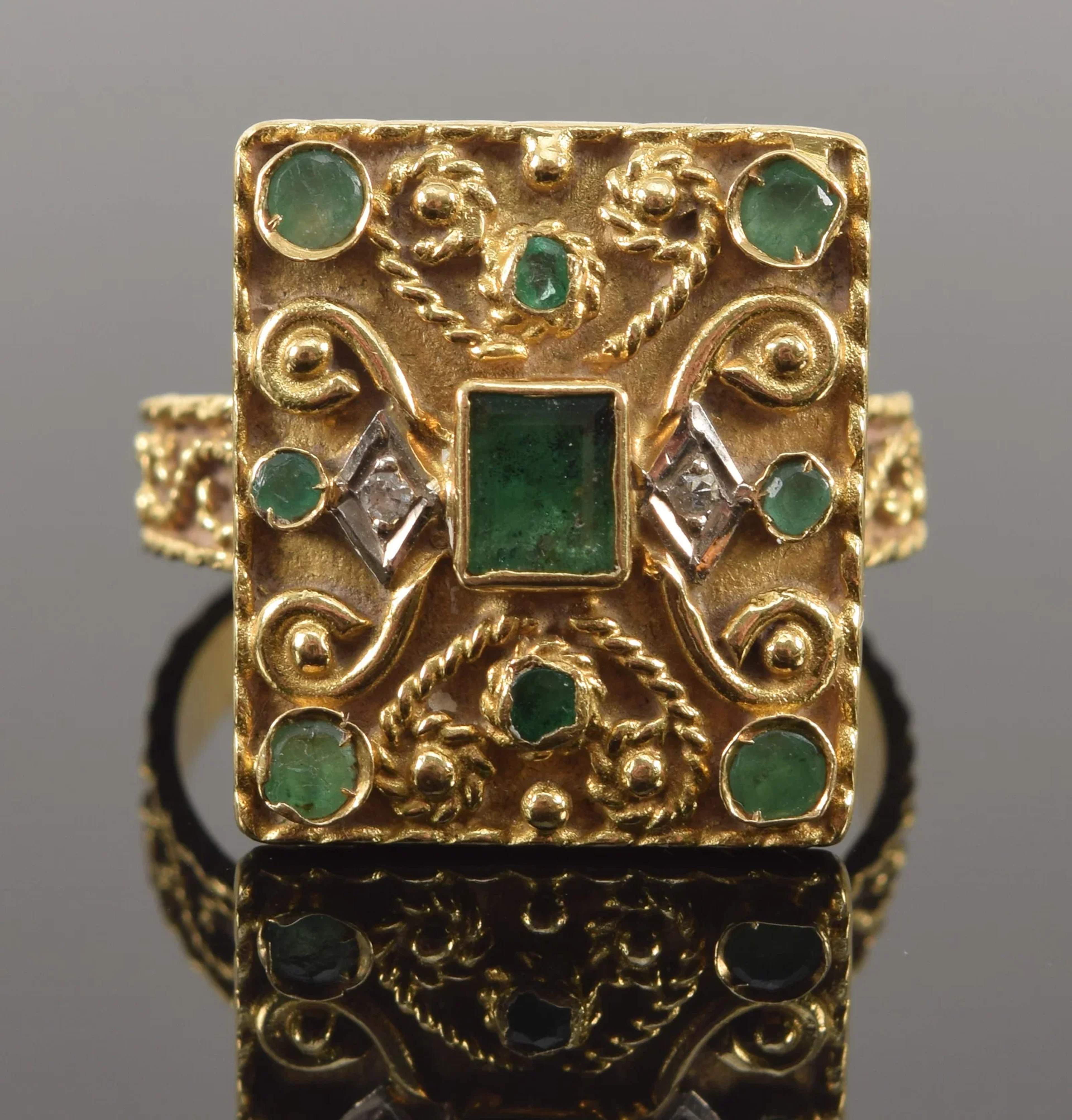 Antique 18K gold emerald and diamond Renaissance Revival ring. Scrolling