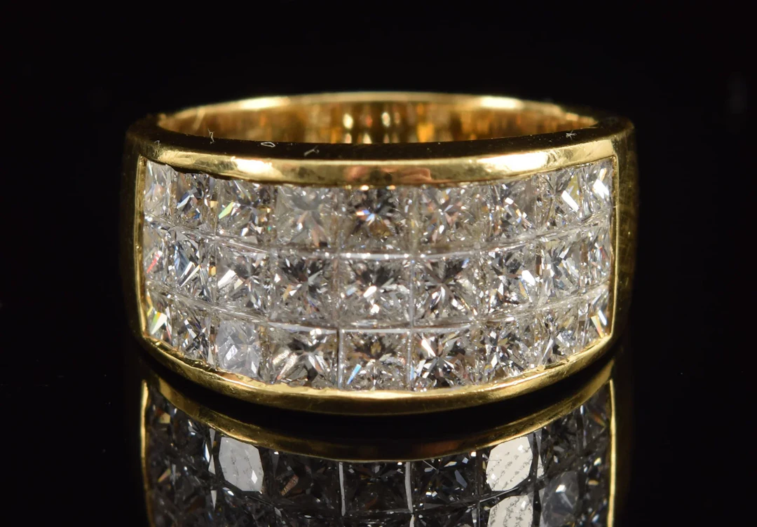 18K gold diamond ring. 3 channels of slightly graduated square cut